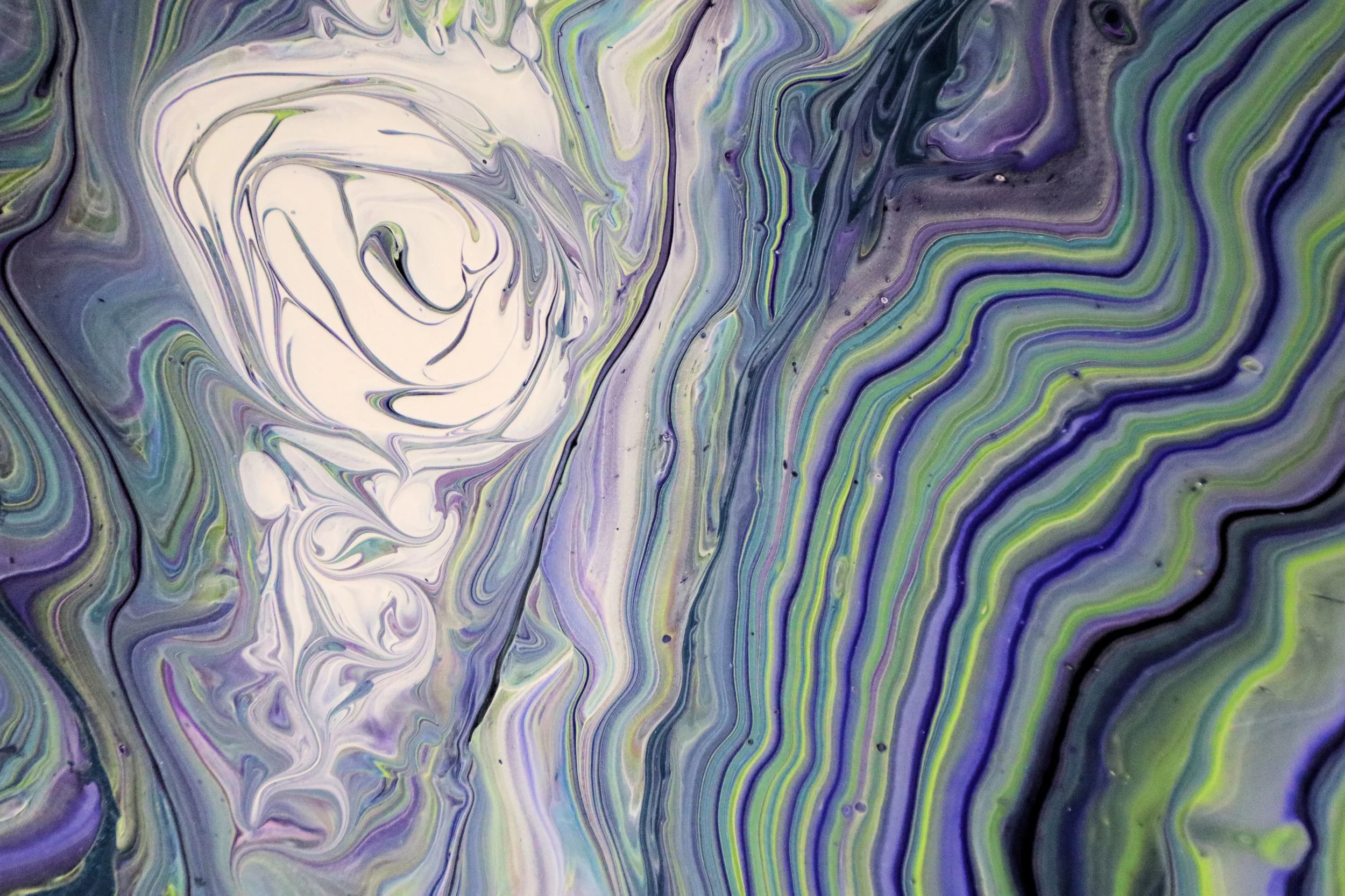 Abstract swirling patterns of purple, green, blue, gray, and black colors.