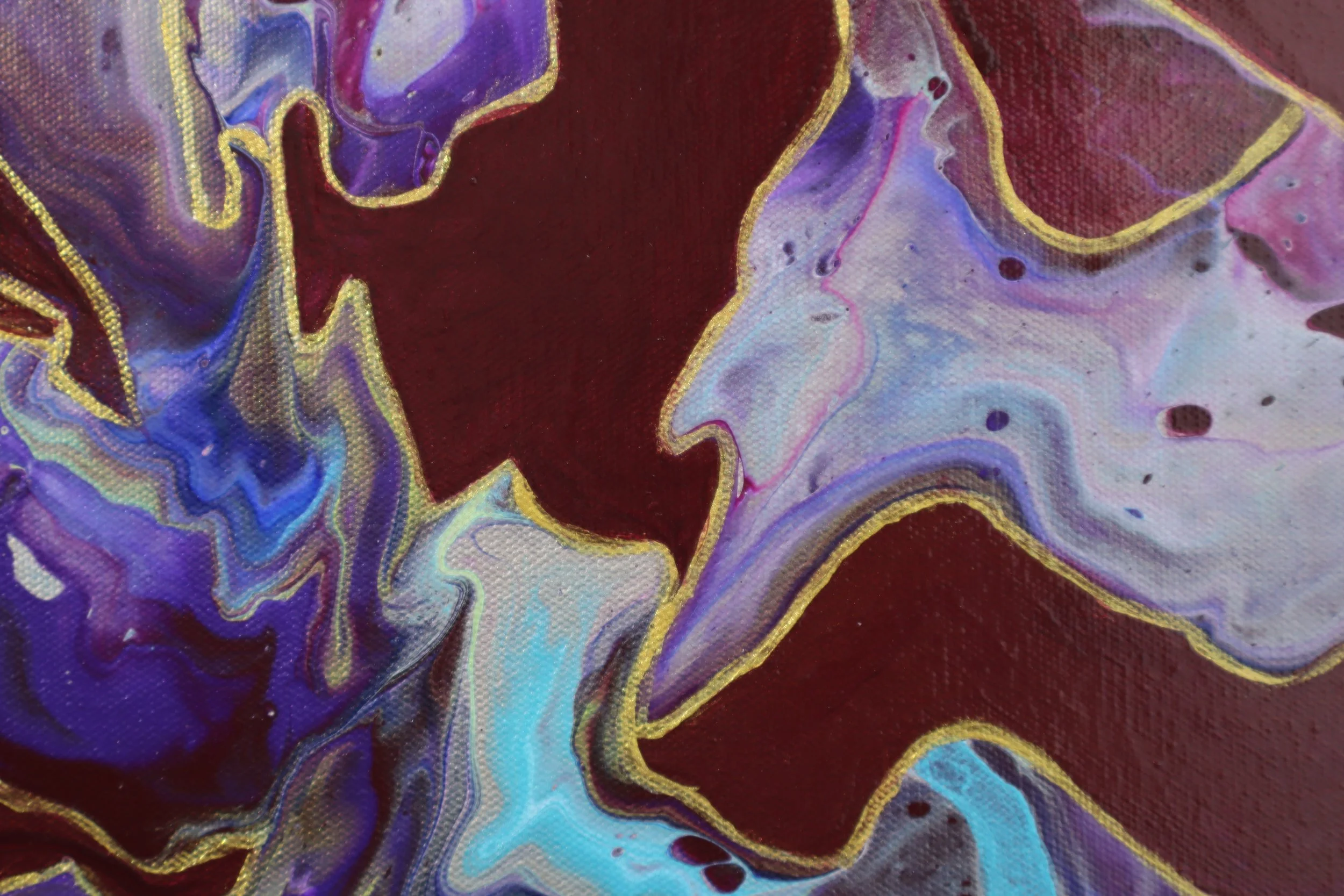 Close-up of an abstract painting with swirling patterns of purple, blue, white, and black, edged with gold outlining.