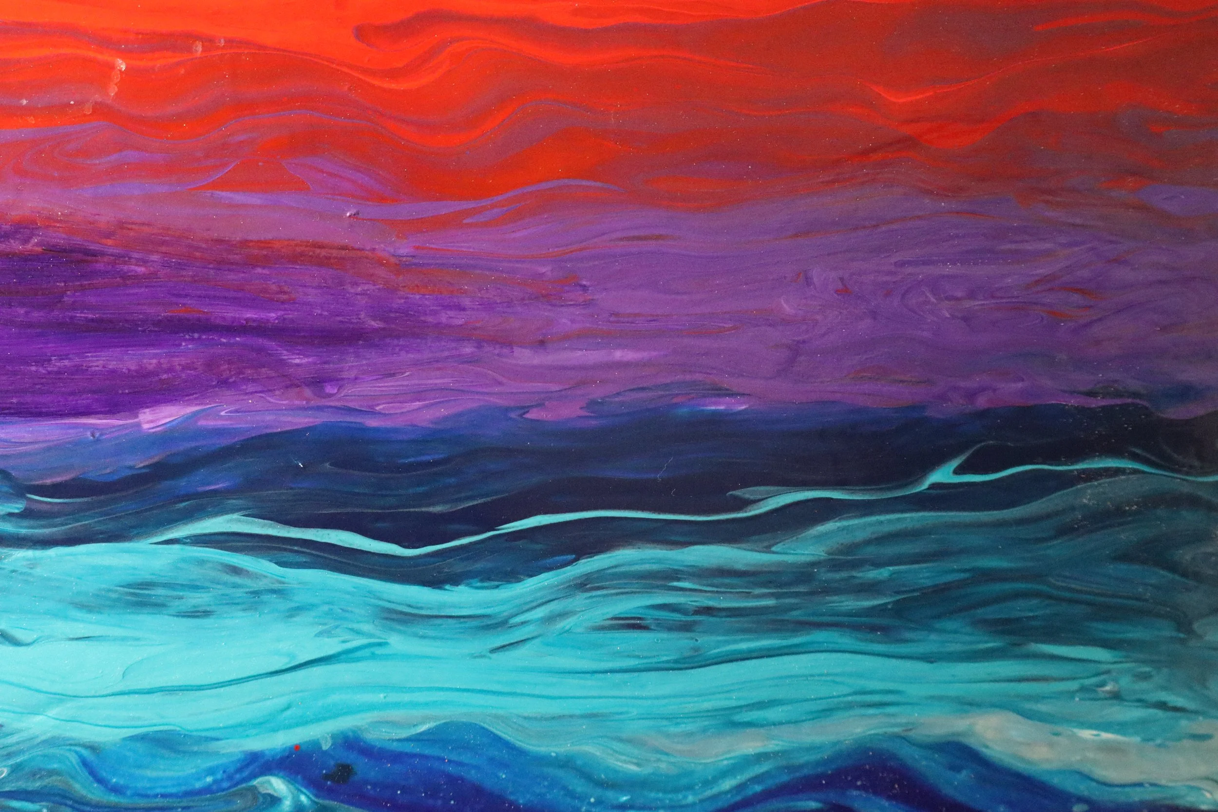 Abstract painting of colorful ocean waves in shades of red, purple, and blue.