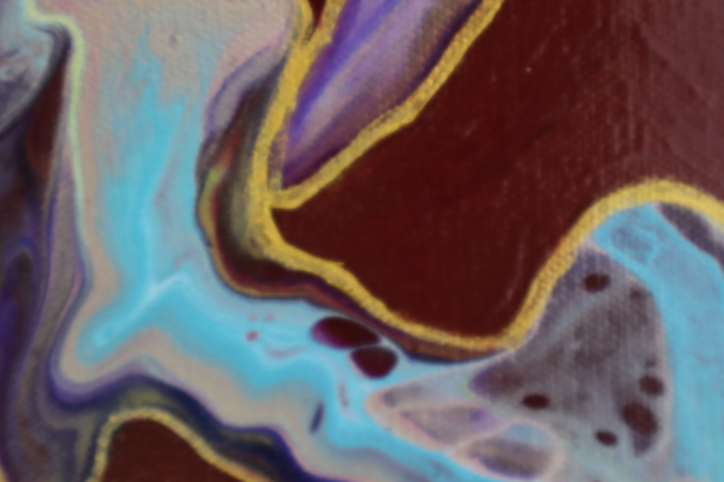 Close-up of colorful, swirling, marbled design with shades of blue, purple, yellow, and brown.