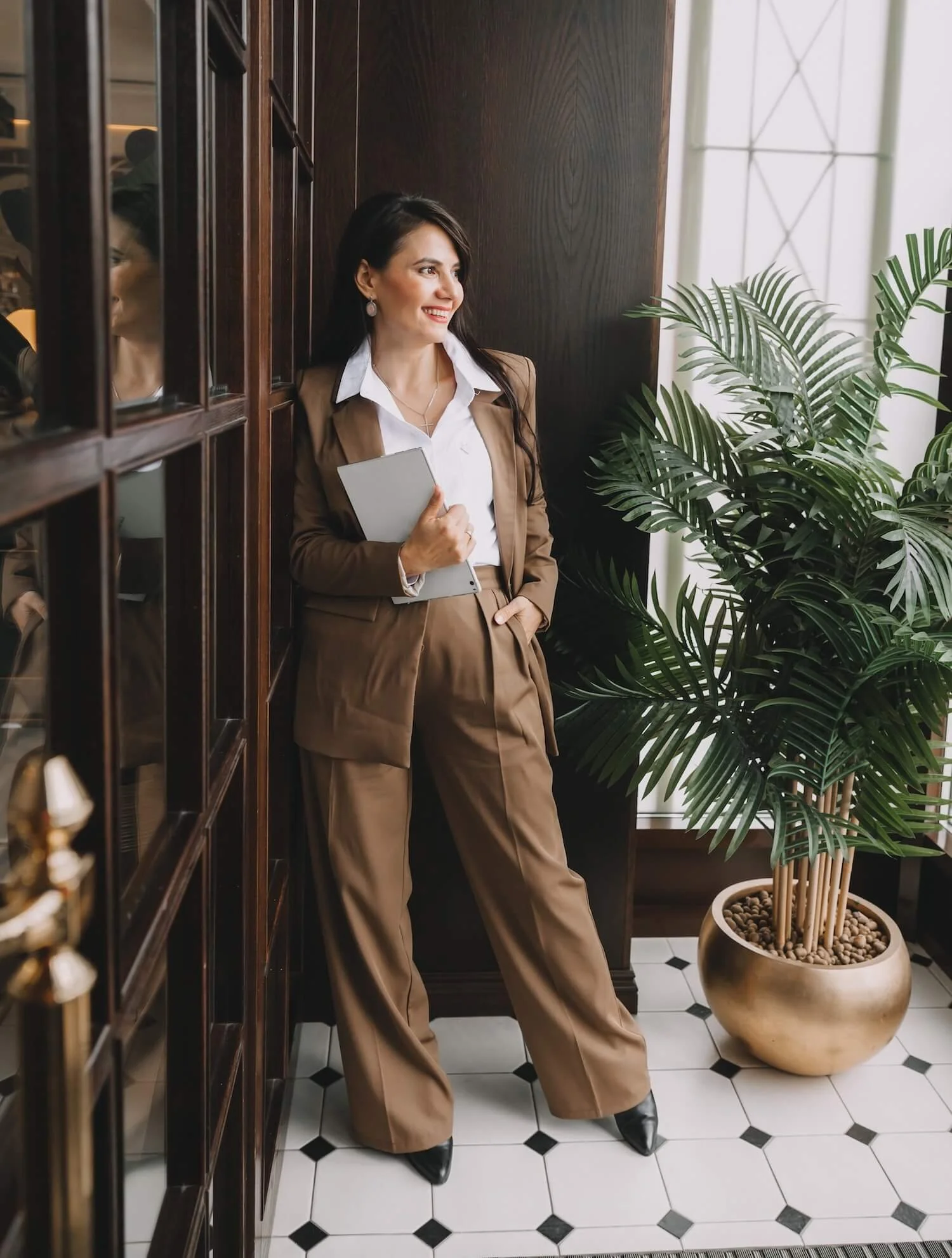Business woman in elegant suit holds notepad.
