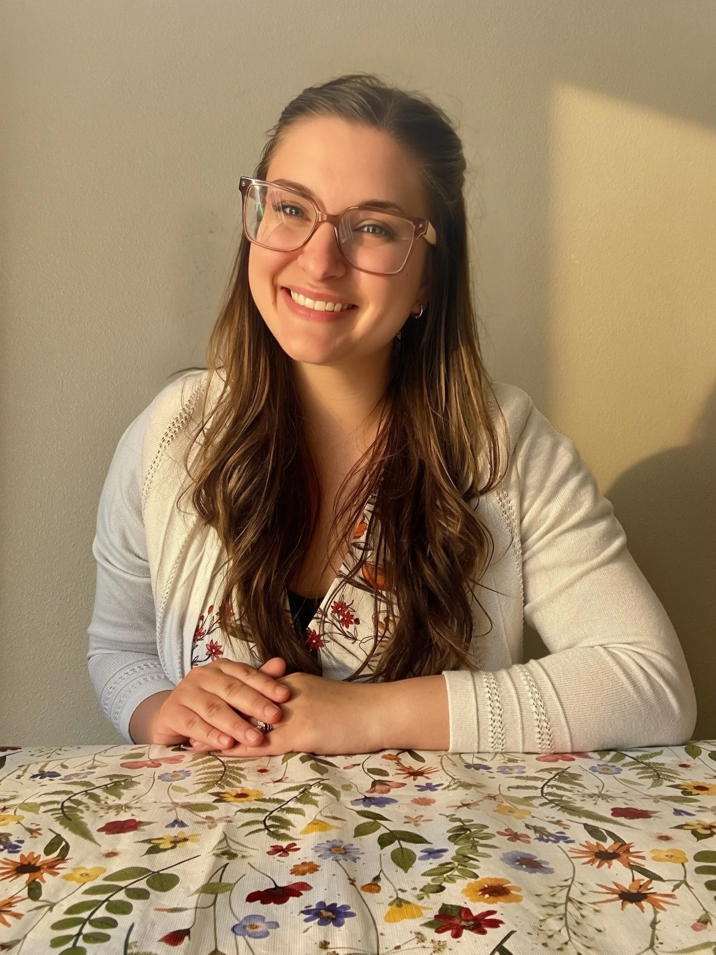 Emily Warren, Oregon REALTOR, smiling while sitting at table.