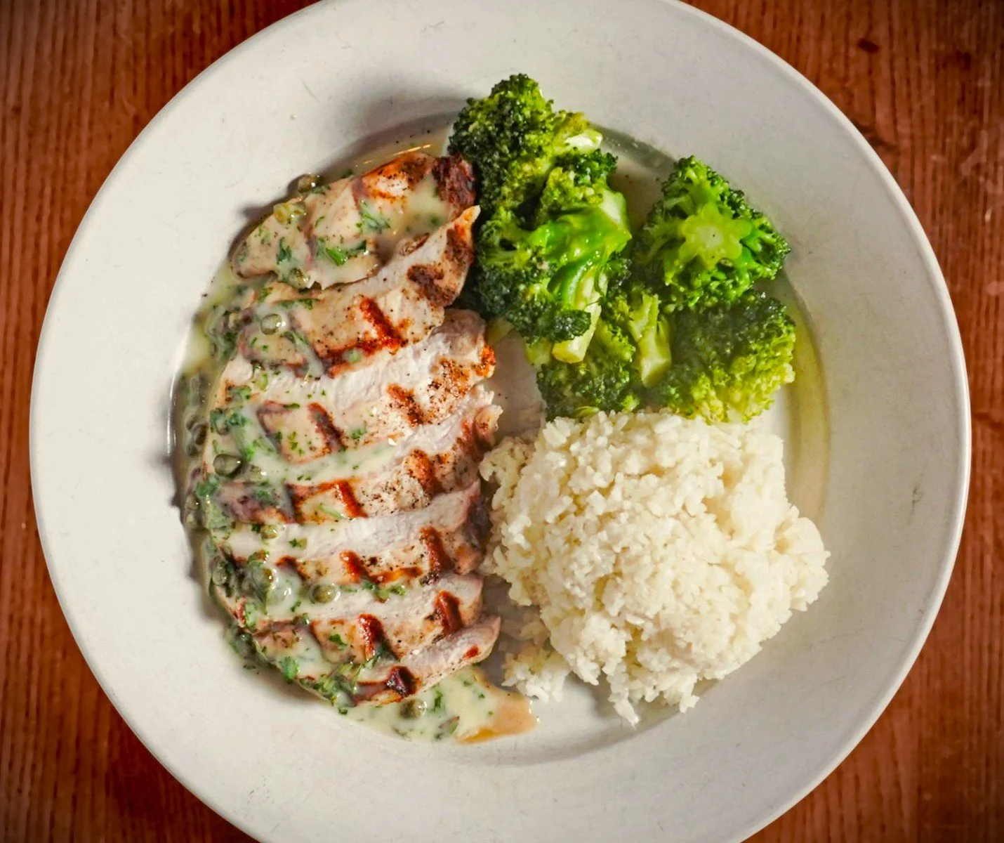 Prestige Farms chicken breast with mashed potatoes, broccoli and a lemon beurre blanc with capers. Windward Tavern in Alpharetta, GA.