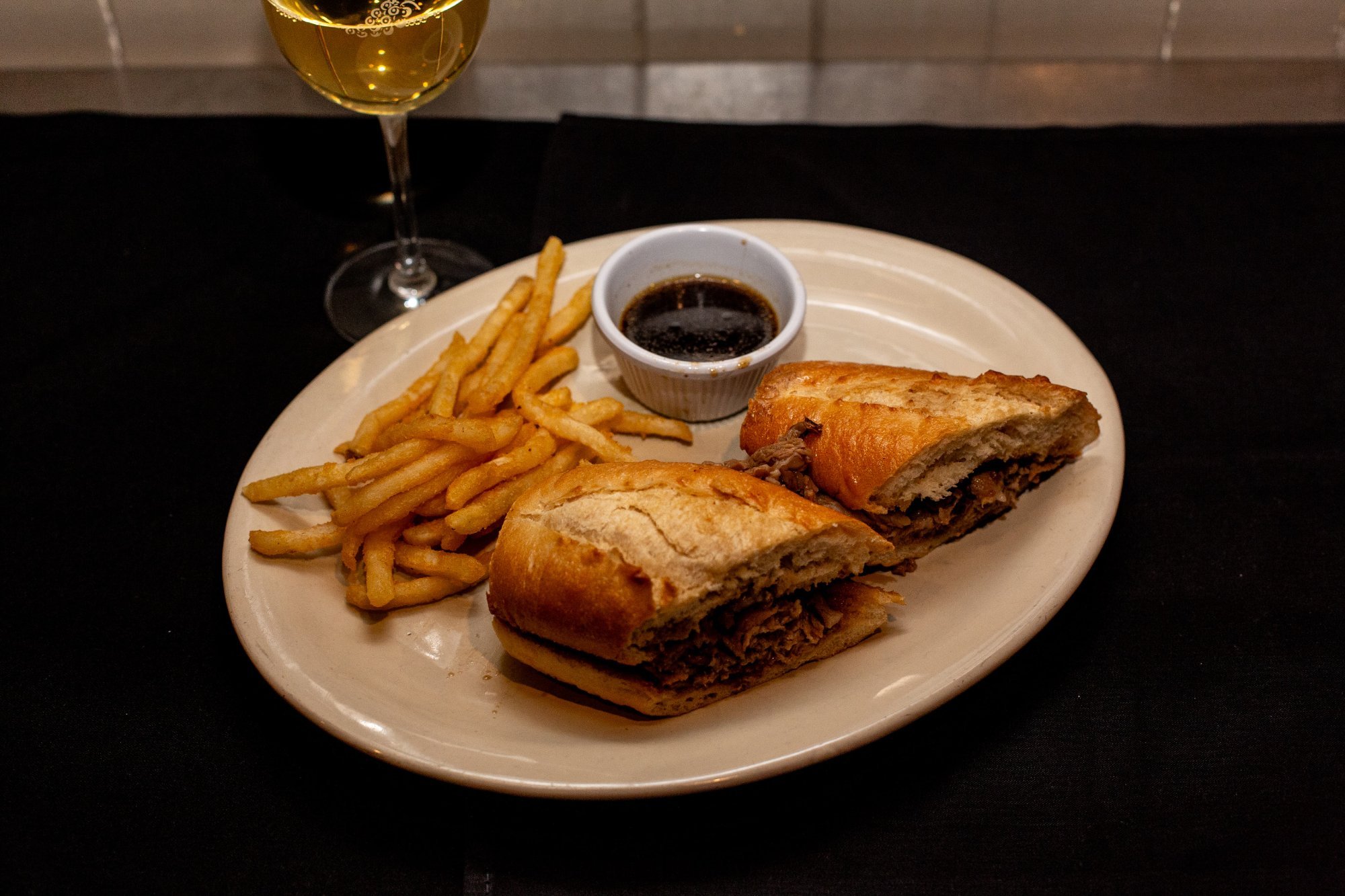 Prime Rib French Dip at Windward Tavern in Alpharetta, Georgia, shaved prime rib on a toasted hoagie roll with au jus and french fries
