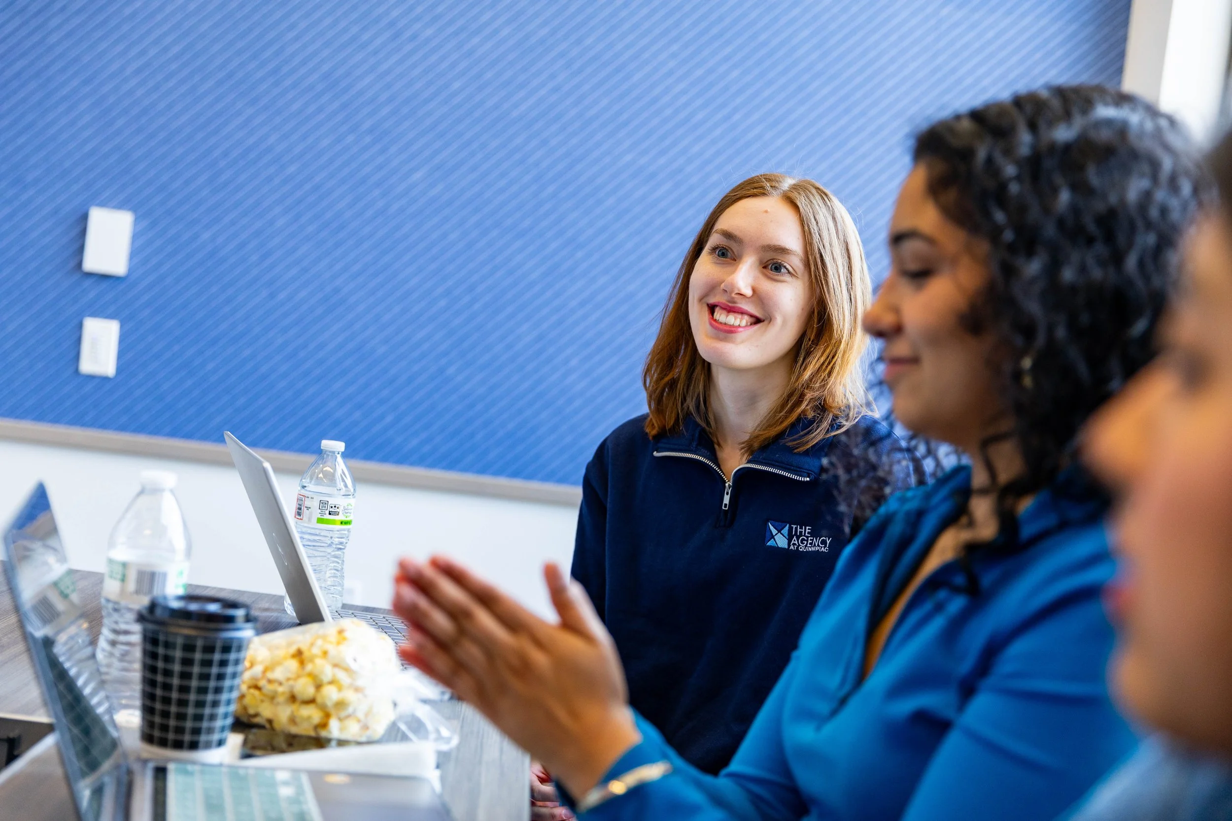 Woman smiling brightly during a TEDxQuinnipiacU meeting