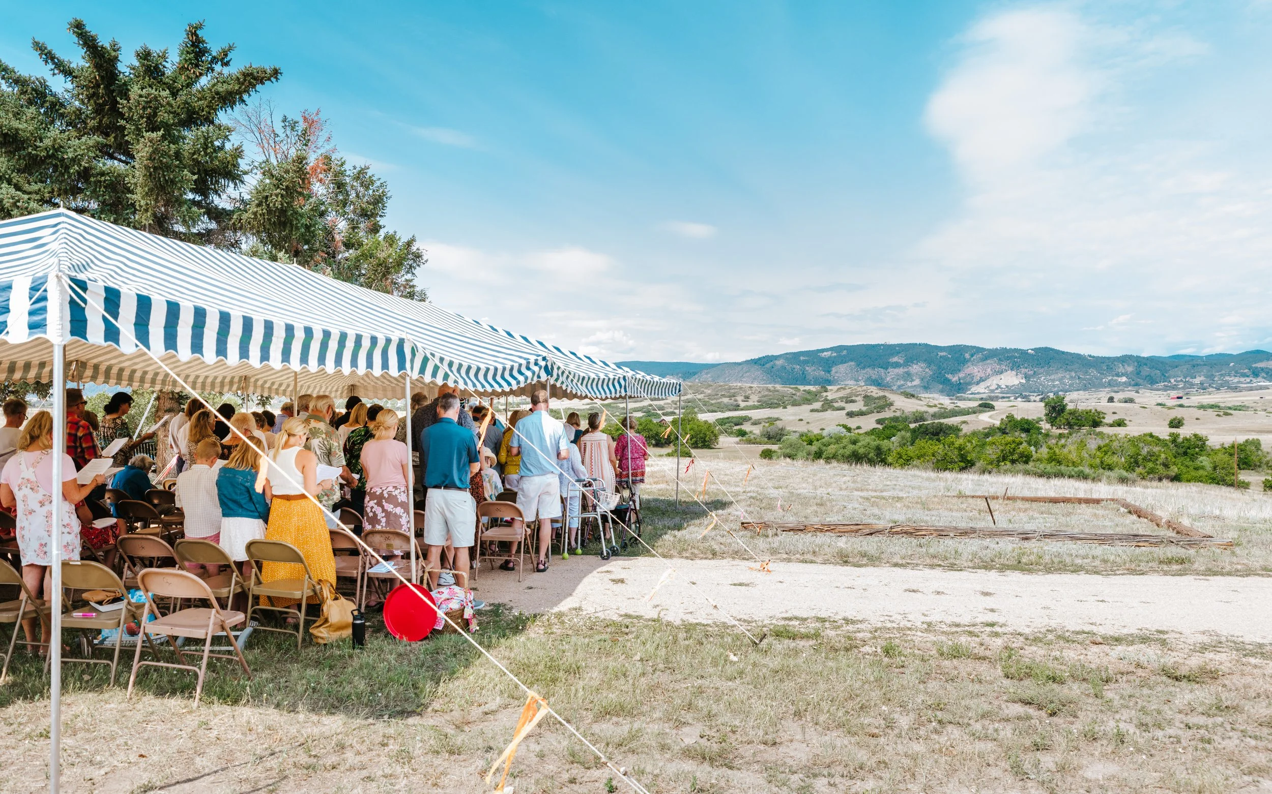 Parishioners enjoying outdoor Homecoming Service and scenic view of western Douglas County foothills