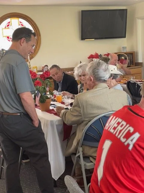 Two U.S. Military Academy (USMA) graduates- Class of '57 an Class of '91- enjoy refreshments in the parish hall after the 2026 Memorial Day ceremony 