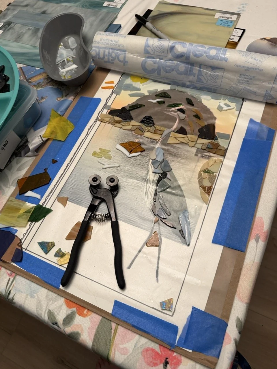 Linda Detwiler Burner creating a mosaic heron artwork using handcrafted glass pieces.