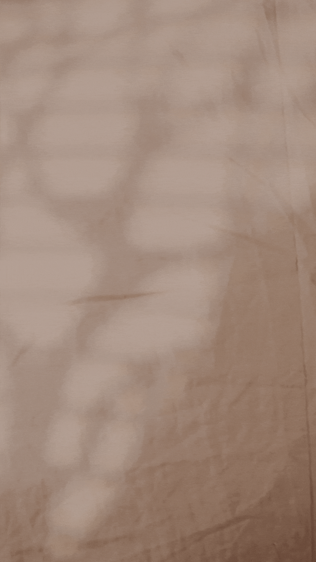 A close-up of a person's face with closed eyes, possibly a woman, on a light-colored background.