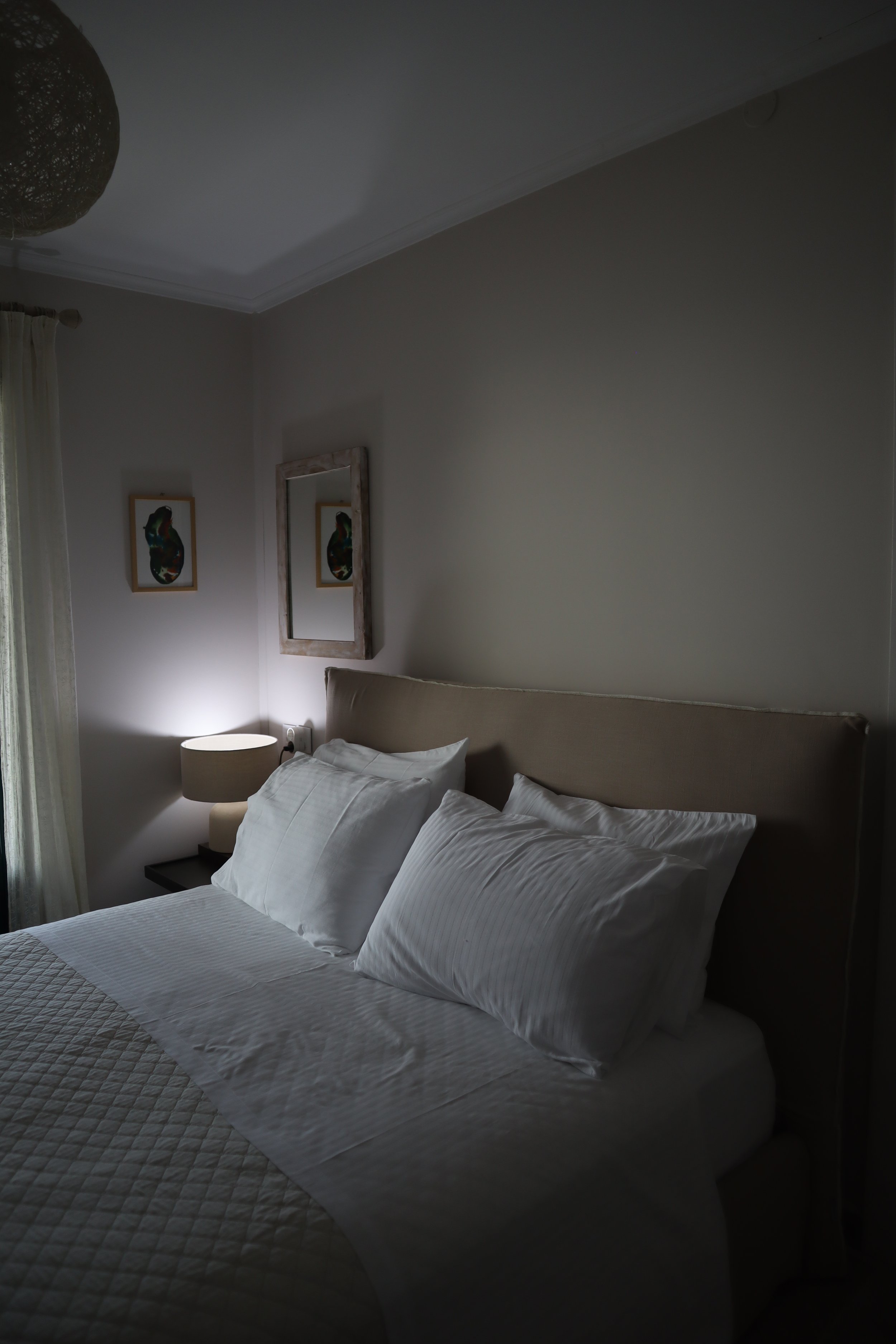 A neatly made bed with white pillows and bedding in a cozy bedroom.
