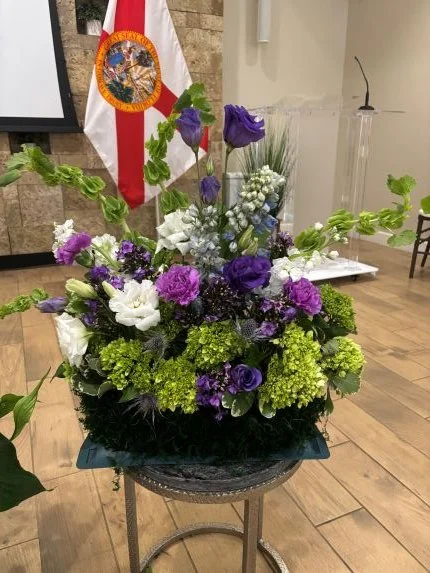 Meadow or floor sympathy flower arrangement with cool colors of green purple and white clearwater