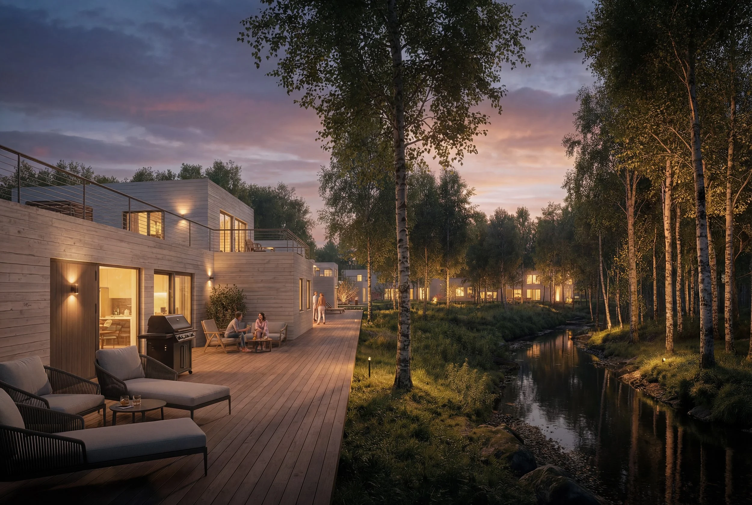 Moderna trähus vid en ås, omgivna av träd och med ett trädäck, där människor gör sociala aktiviteter på kvällen, med ljus som lyser inifrån huset, och en solnedgång i bakgrunden.