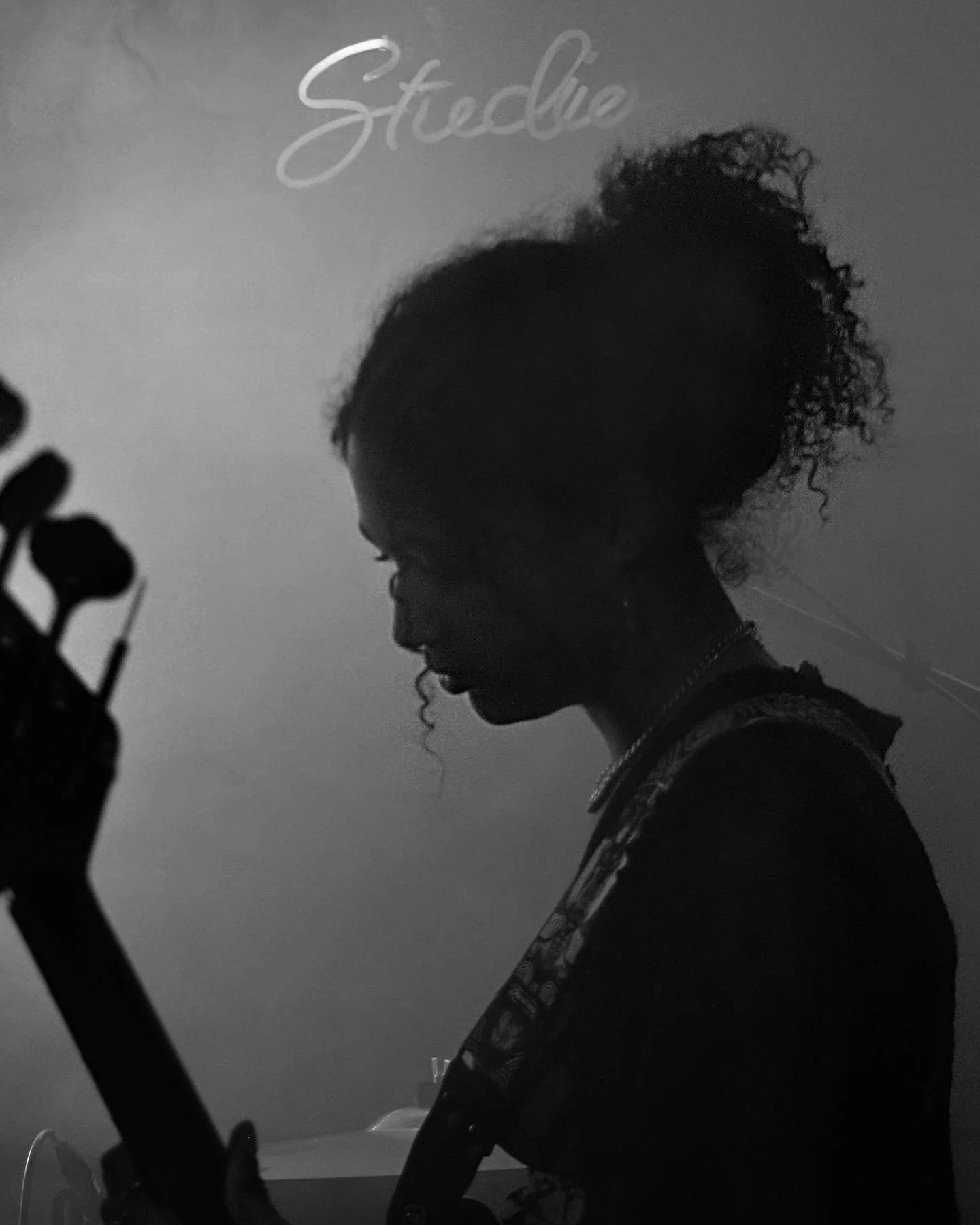 Silhouette of a woman playing guitar, with the word 'Stellie' written in cursive above her head.