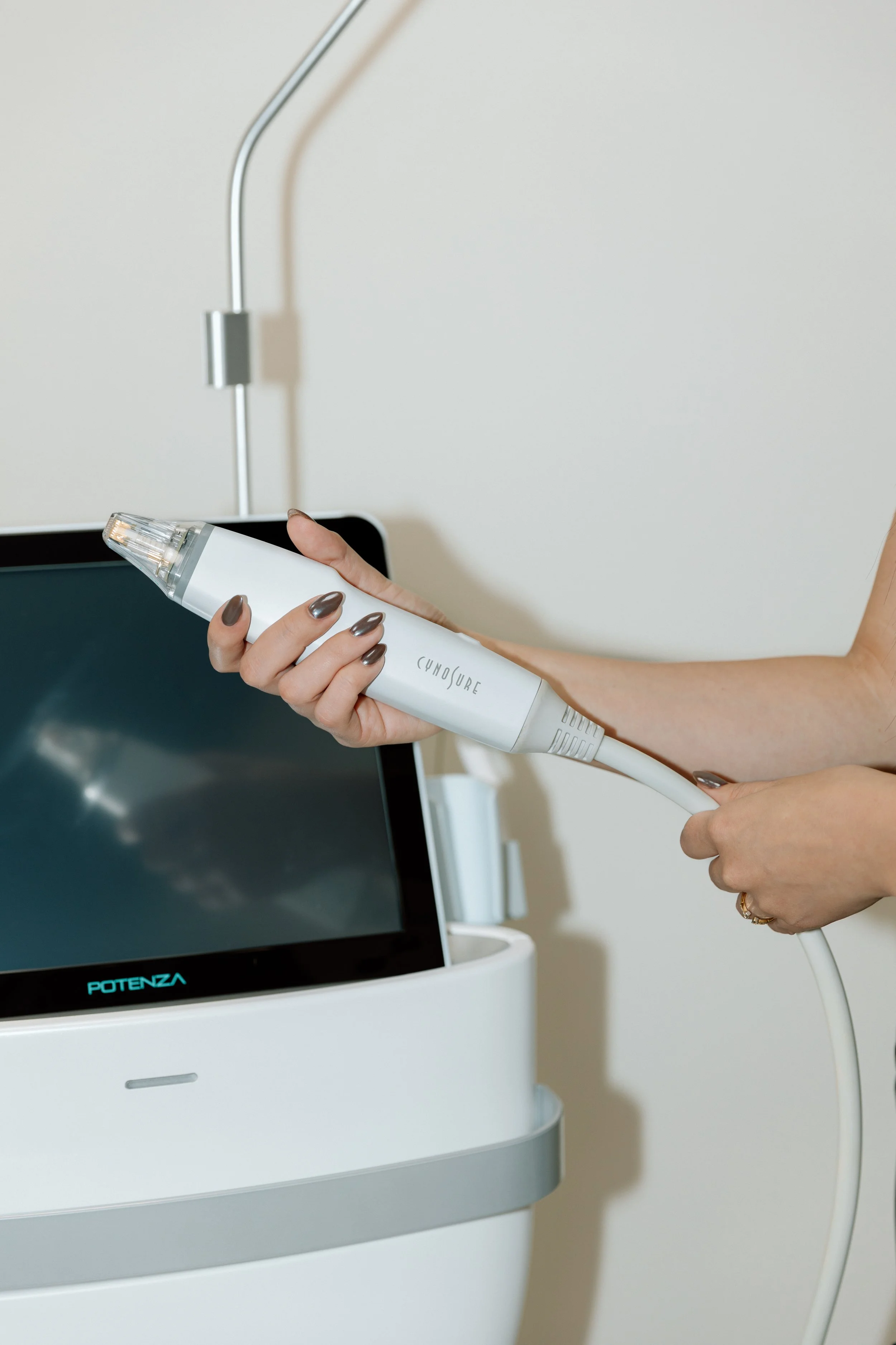Person holding a medical ultrasound device with a tablet in the background.