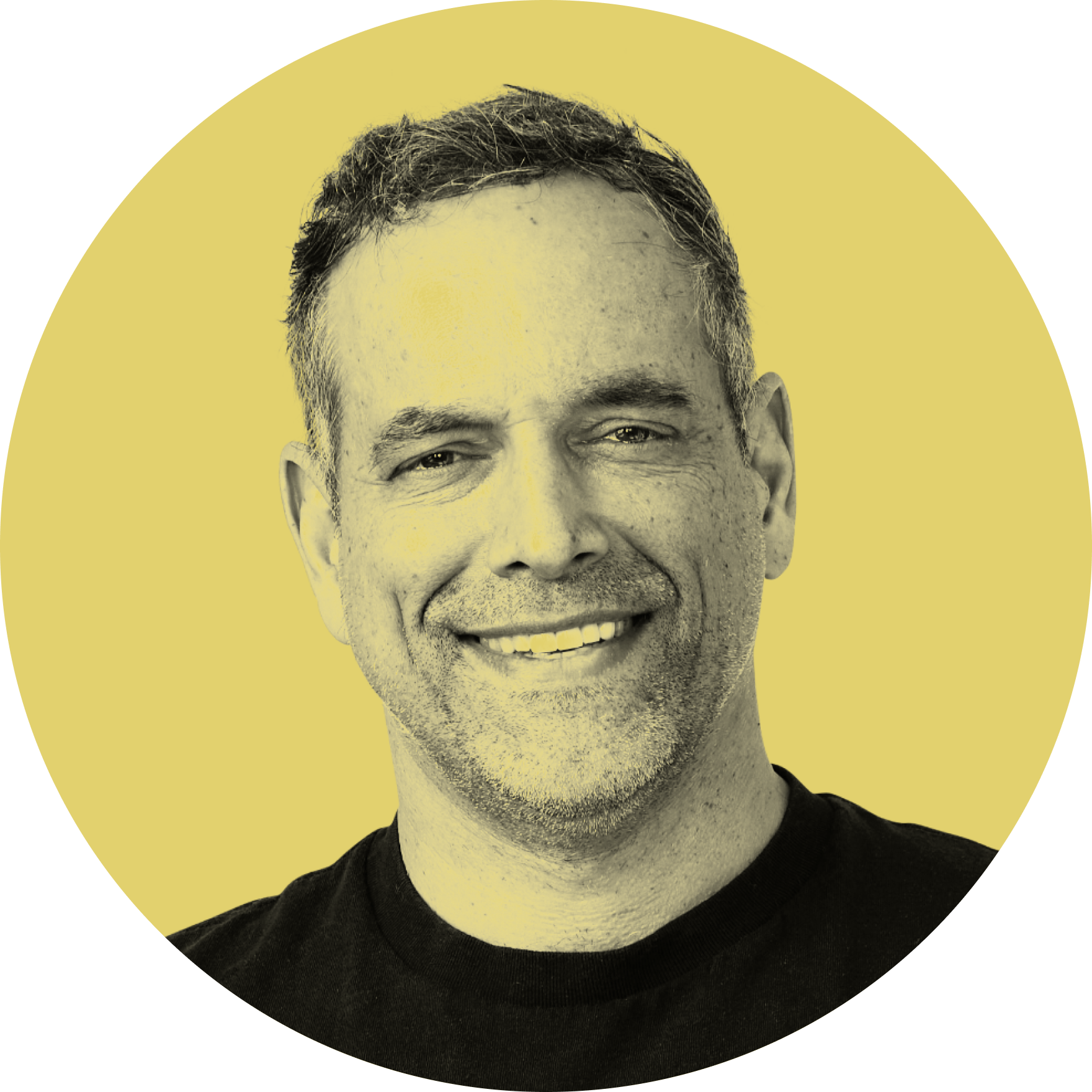 Close-up of a smiling man with short curly hair, wearing a black shirt, against a solid yellow background with a black corner segment in the upper left.