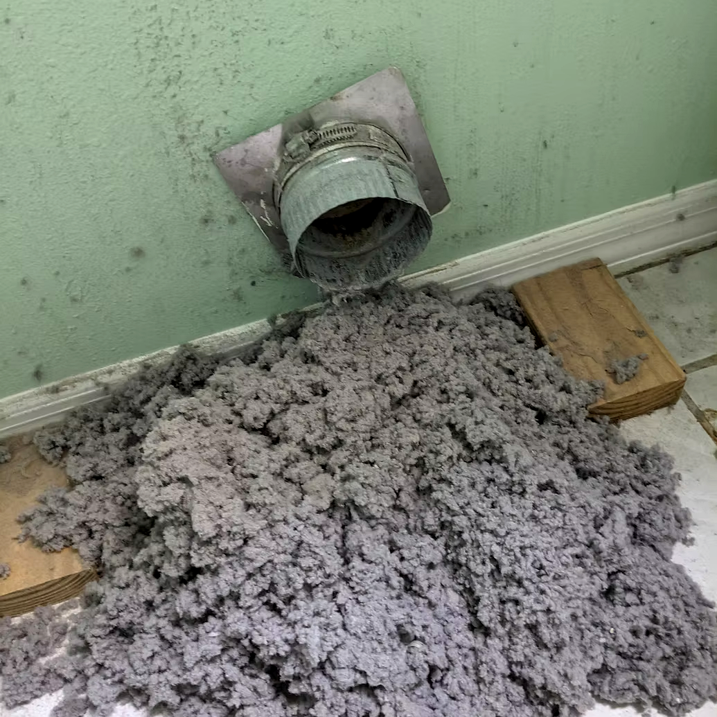 A plumbing vent pipe with drywall mud and debris spilled on the floor.