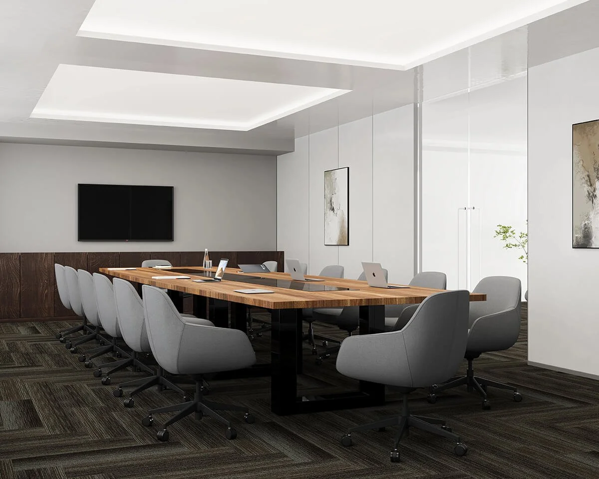 Modern conference room with a large wooden table, ten gray office chairs, a wall-mounted TV, abstract artwork, and a glass wall with a plant in the background.