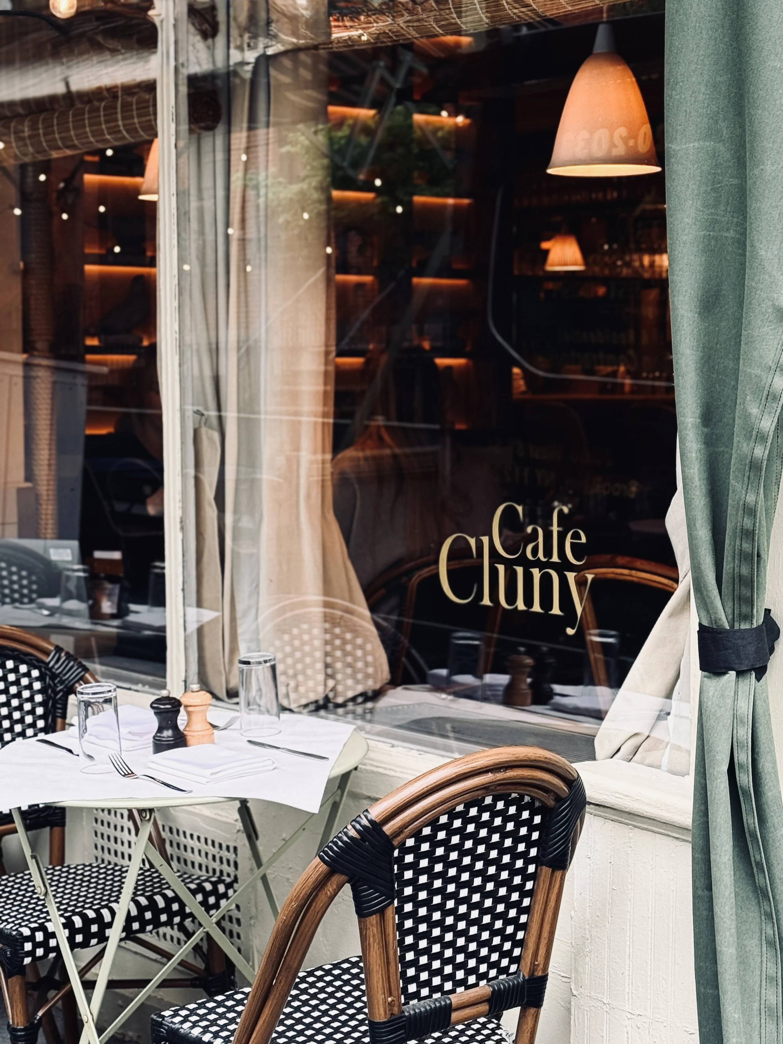 Café Cluny dining room through the window, gold lettering and bistro chairs, West Village