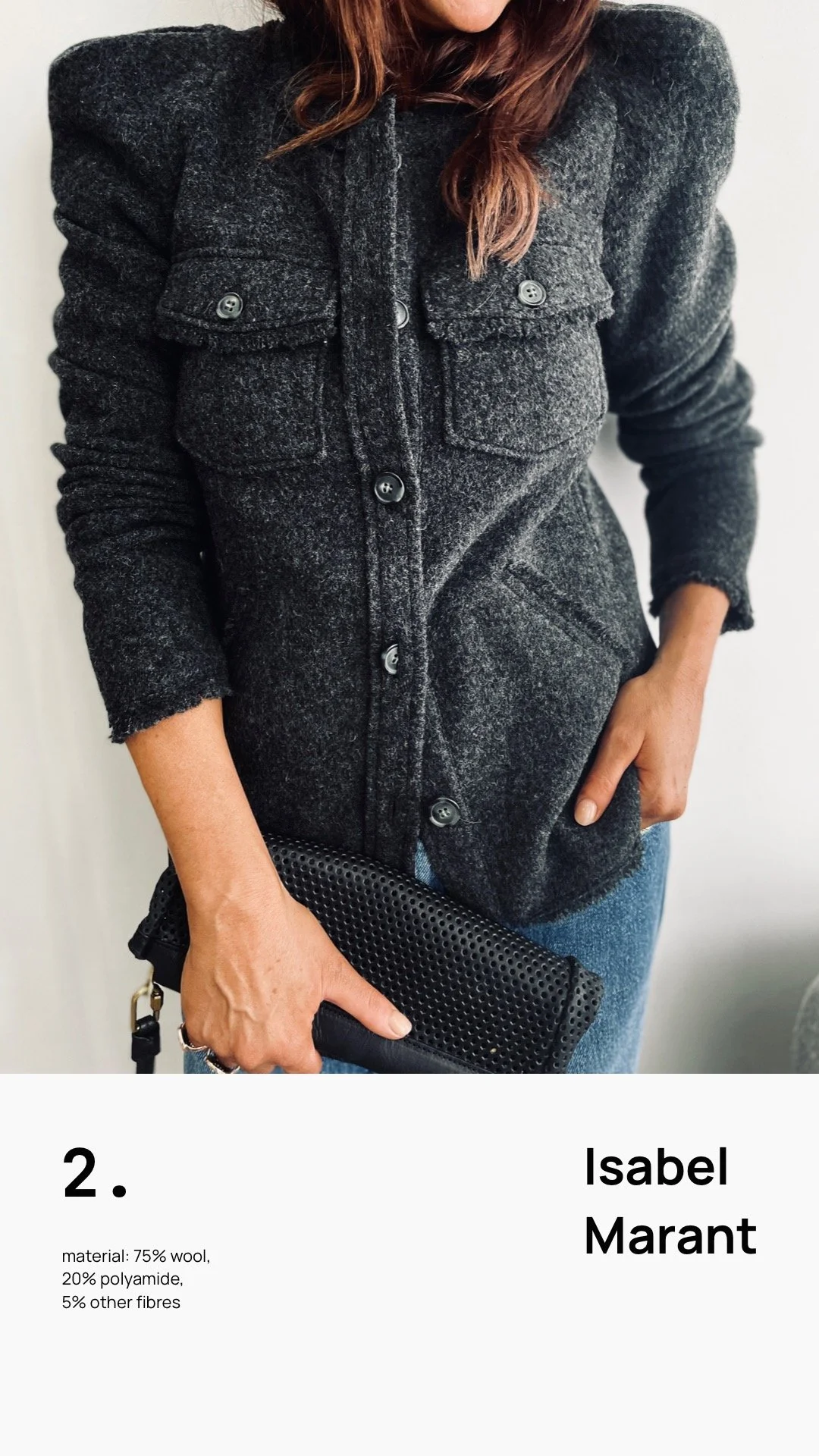 Close-up of a person wearing a dark grey woolen coat with buttons, holding a black perforated clutch, and blue jeans, against a plain background.