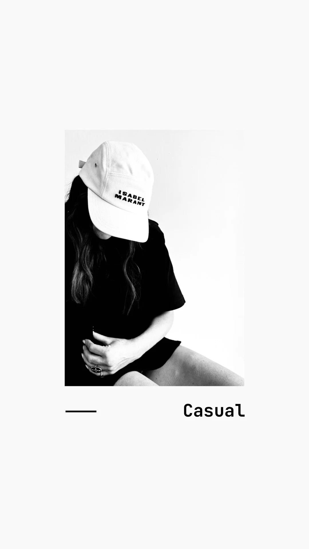 Black and white photo of a woman wearing a baseball cap with 