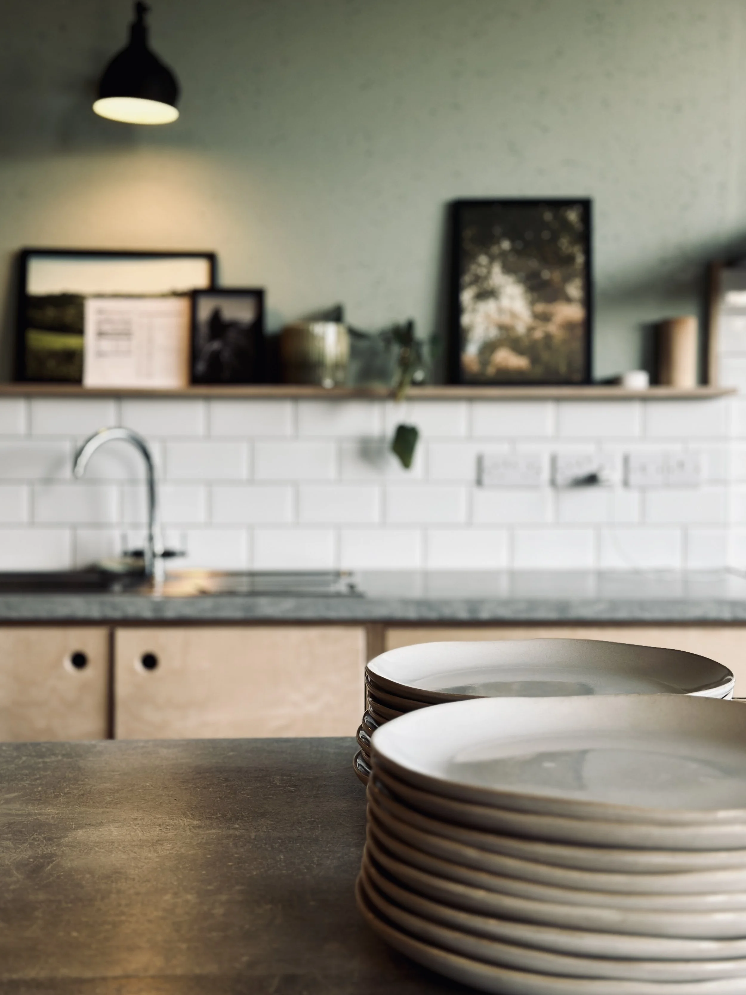 Stacked white plates on a wooden kitchen countertop
