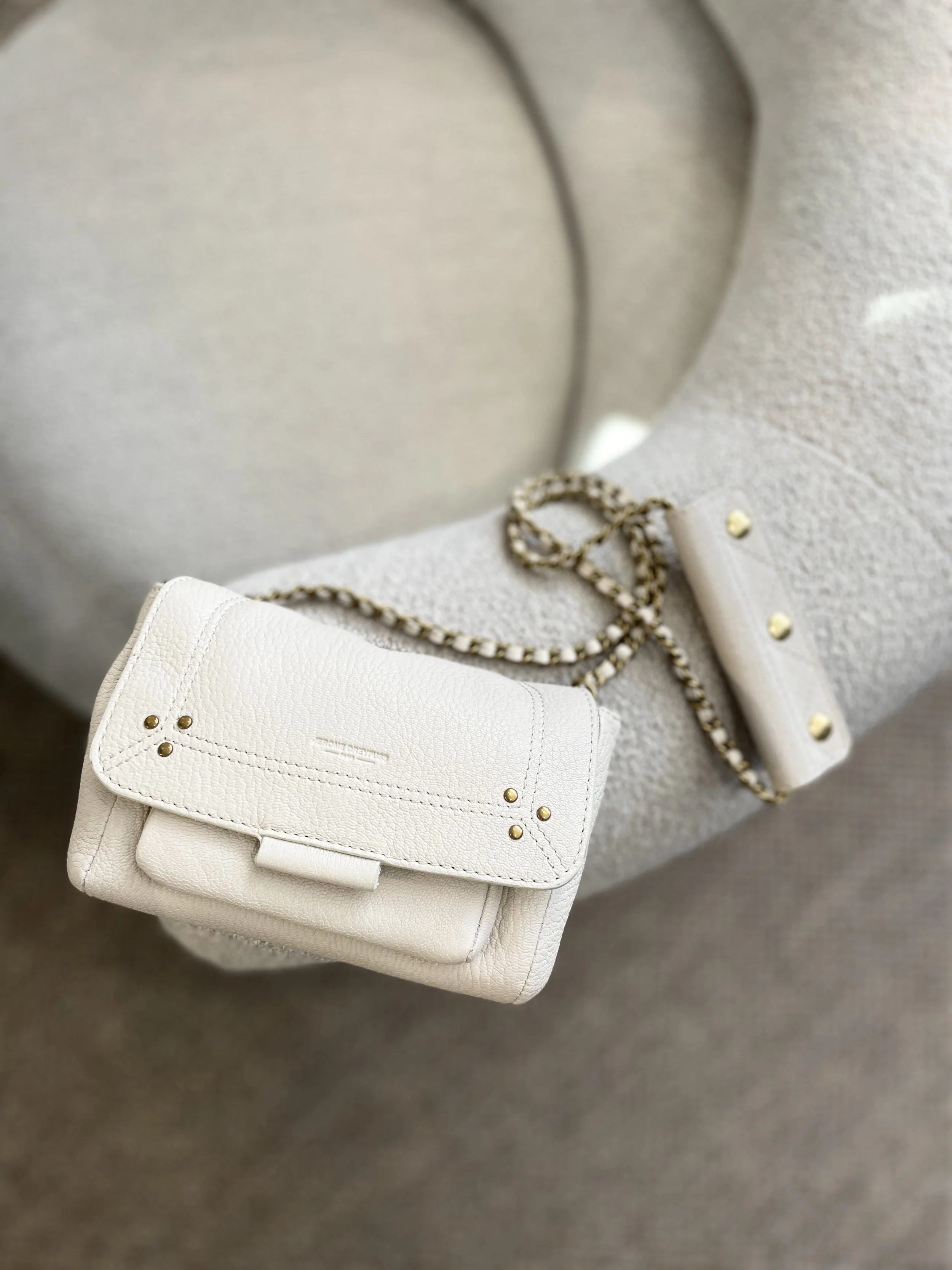 White leather bag and accessories styled on neutral background, brand photography by MUSE Creative Studio Brighton