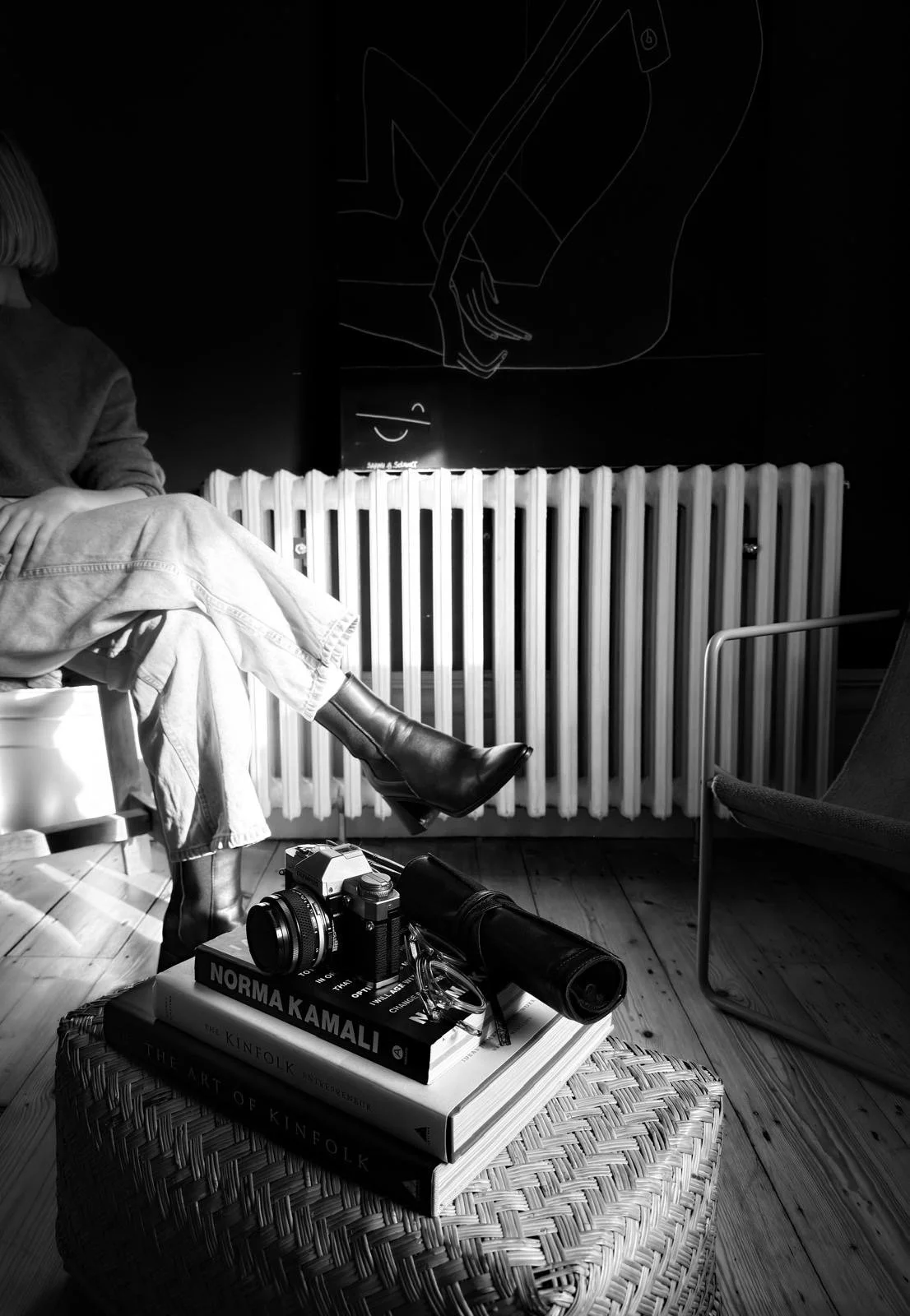 woman sitting on the chair with crossing legs, wearing boots.