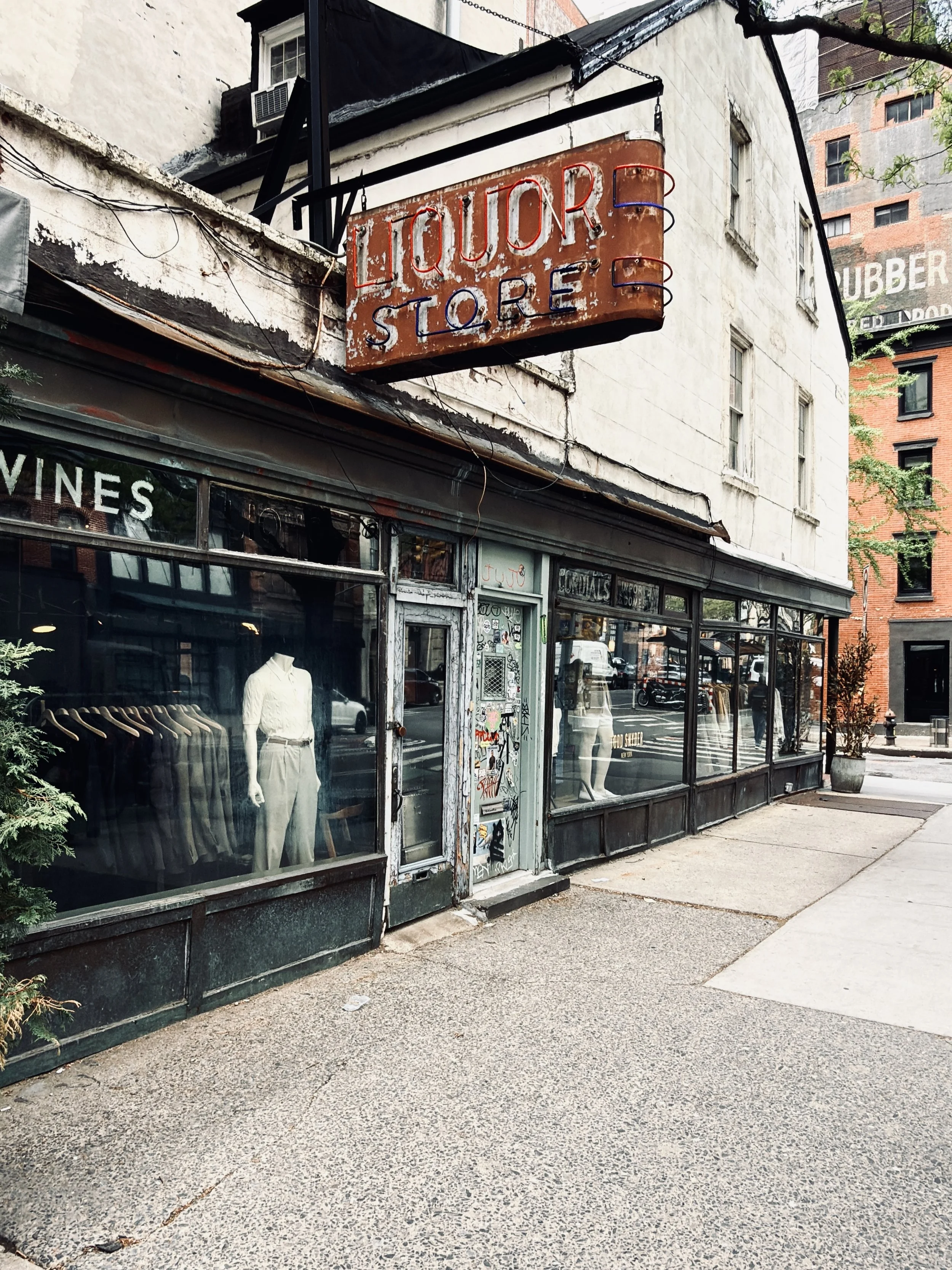Hanging Liquor Store sign above a "Wines" shop window now selling clothing, Tribeca