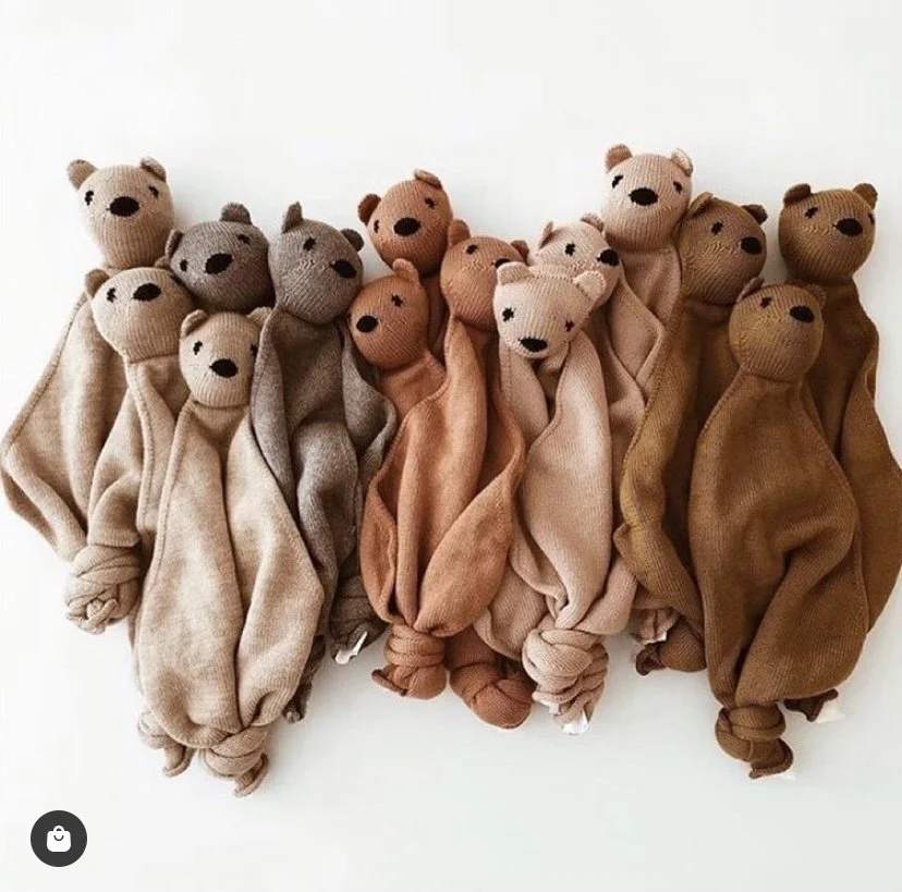 Group of beige, gray, brown, and tan teddy bear plush toys with knotted legs, arranged on a white surface.