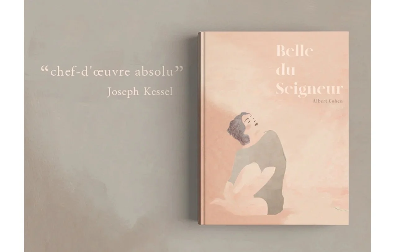 A pink book titled "Belle du Seigneuur" by Albert Cohen with an illustration of a woman on the cover, and a quote on the wall to the left that says "chef-d'œuvre absolu" by Joseph Kessel.