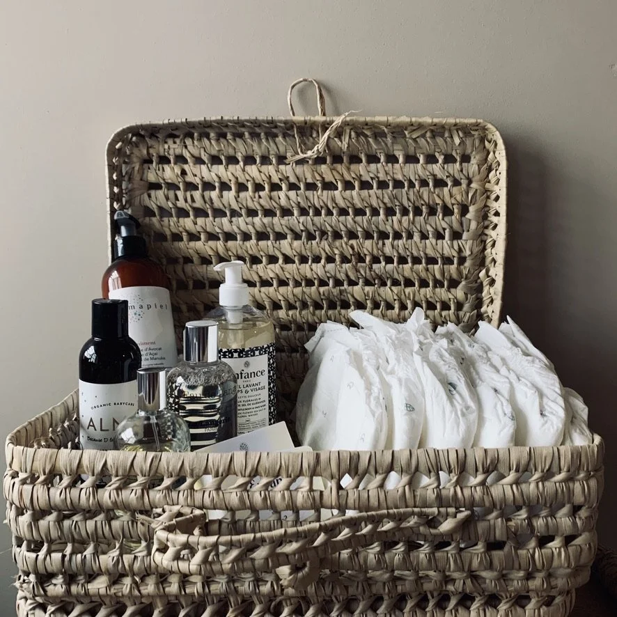 A woven basket filled with bottles of skincare products and neatly wrapped packages.
