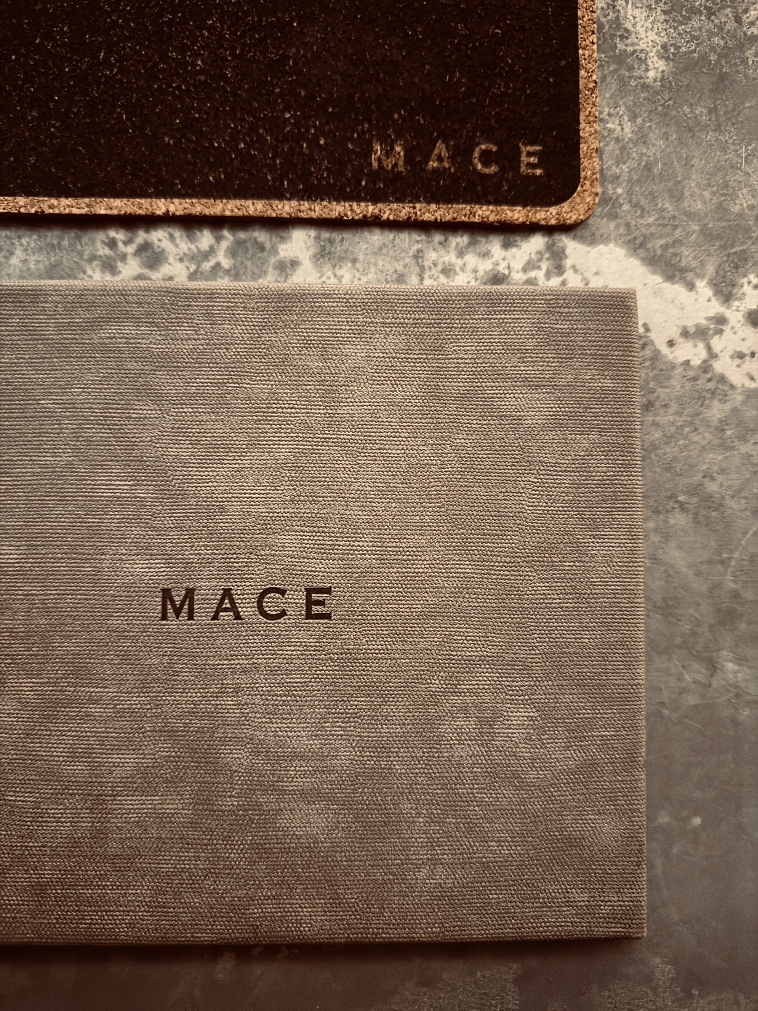 Mace cocktail bar menus with embossed logo on textured stone, New York