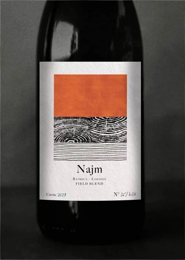 A wine bottle with a label featuring an abstract design of horizontal lines and a fingerprint pattern, labeled 'Najm' from Batroun, Lebanon, vintage 2019.