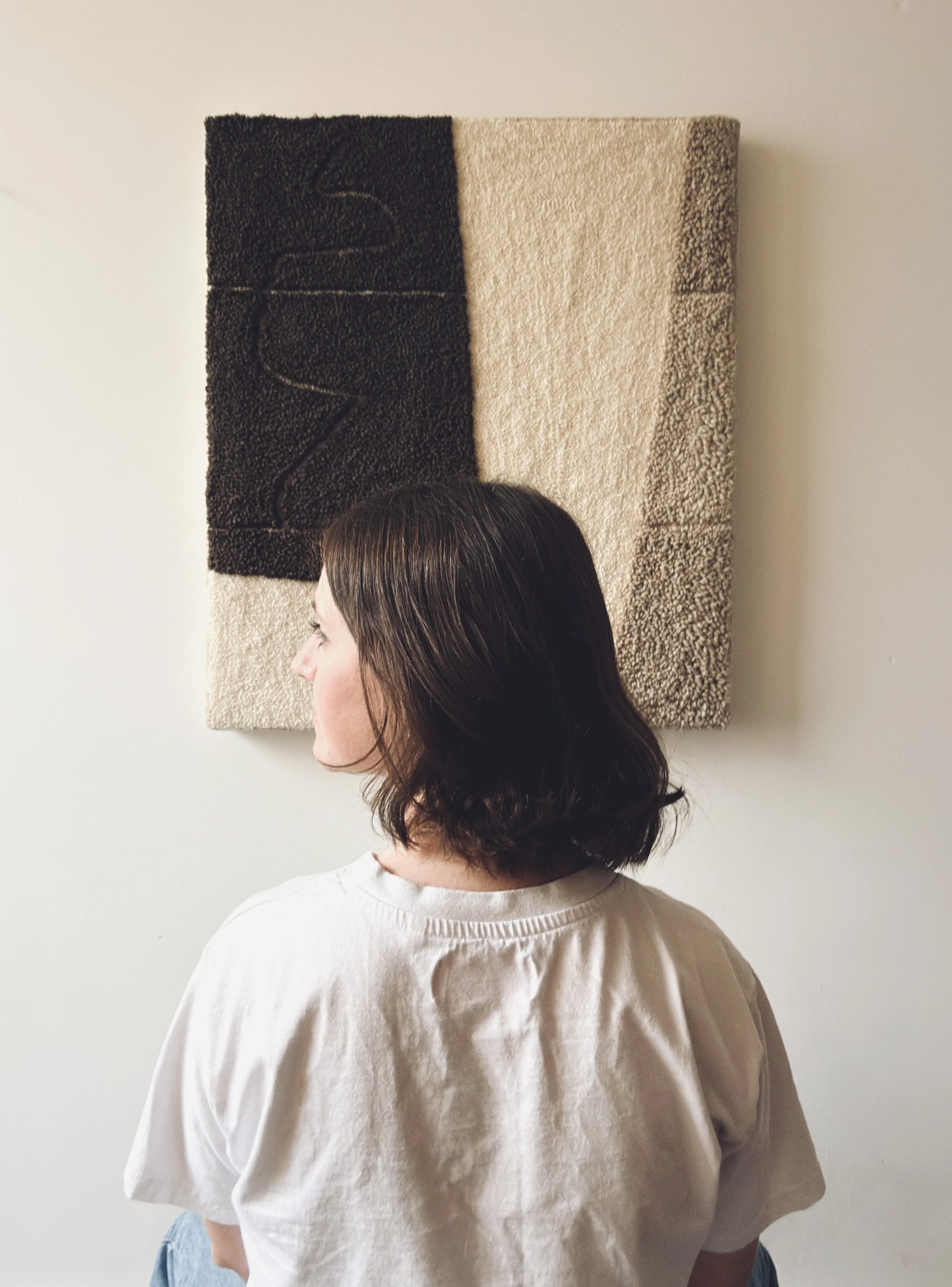 Textile artist Alice Liptrot standing in front of her punch needle work, artist feature by MUSE Creative Studio Brighton