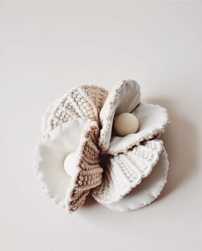 Cream and white scrunchies with wooden beads inside on a white background.