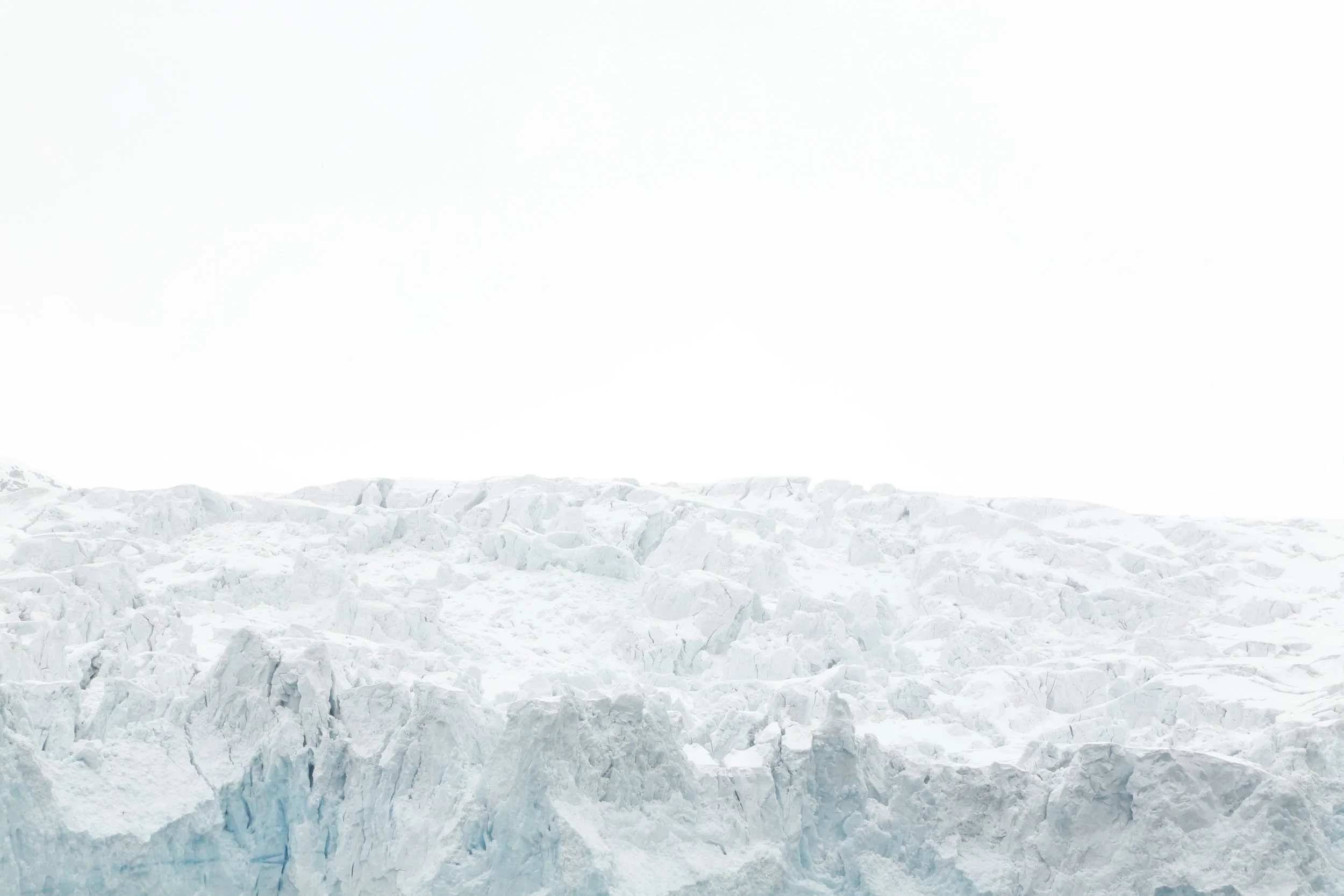 A glacier with a mostly white sky in the background.