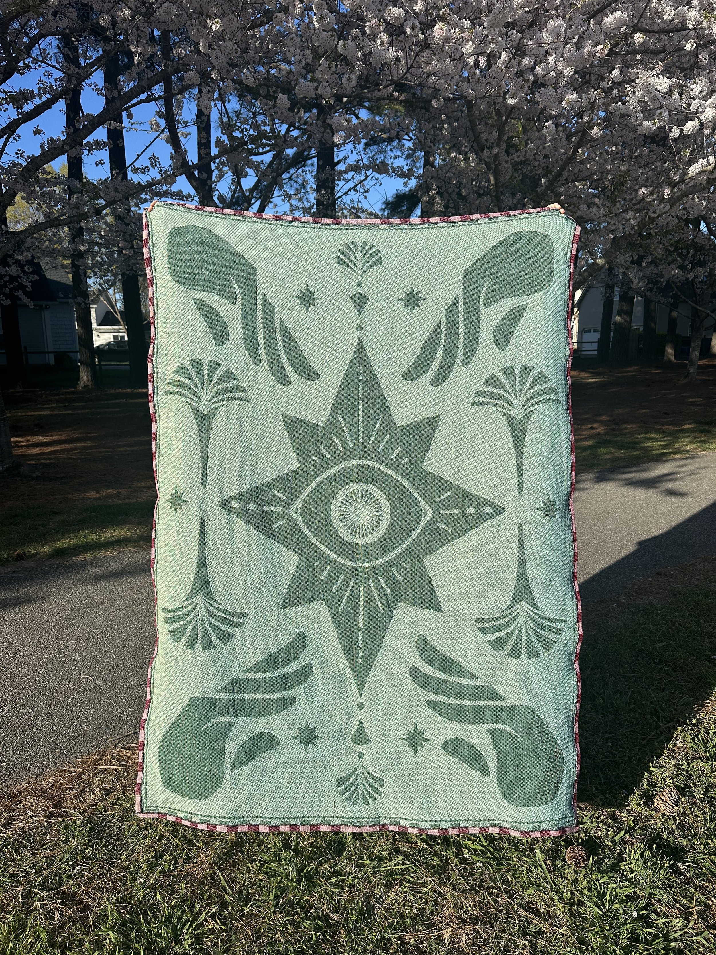 The reverse of the blanket is pale pistachio green and aqua, the colors and values are inverted because of the nature of the weaving process. On this side you can see the hand sewn rolled hem