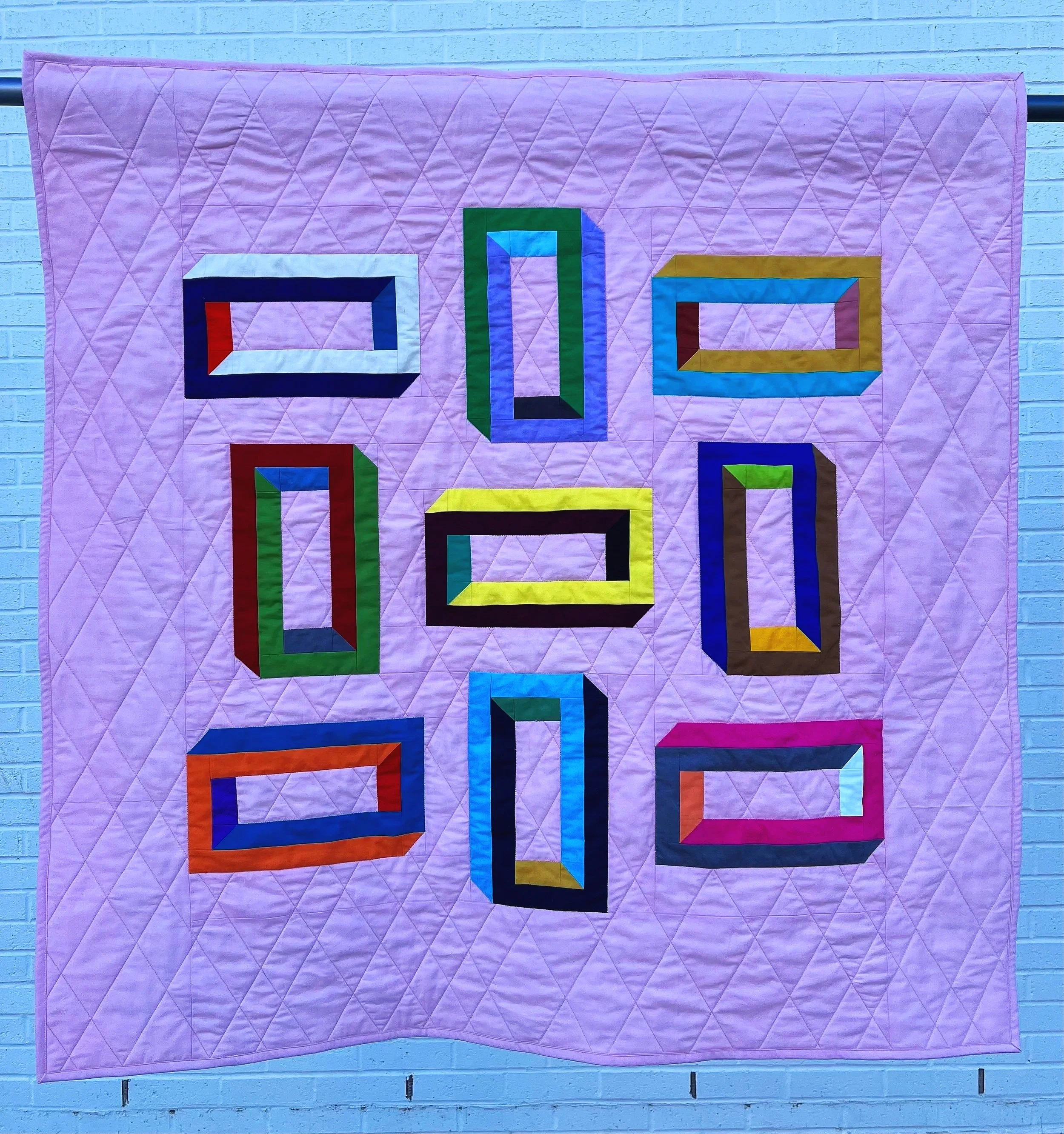 Tizit
2023
Cotton fabric and batting, polyester thread 
42" x 42"

My youngest son brought home a math worksheet with this design of an impossible shape, and I couldn’t get it out of my head. I used lots of various shades and colors to create my own 