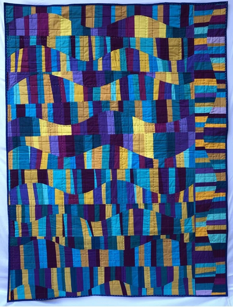 Sinusoidal Sunset
2021
Cotton fabric and batting, polyester and cotton thread
53" x 60"

Blocks made by members of Solid Seven, piecing and quilting by E. A. Cox

Hung at QuiltCon 2022
