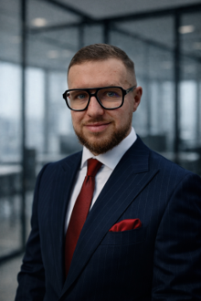 Businessman in a suit and glasses standing in an office building