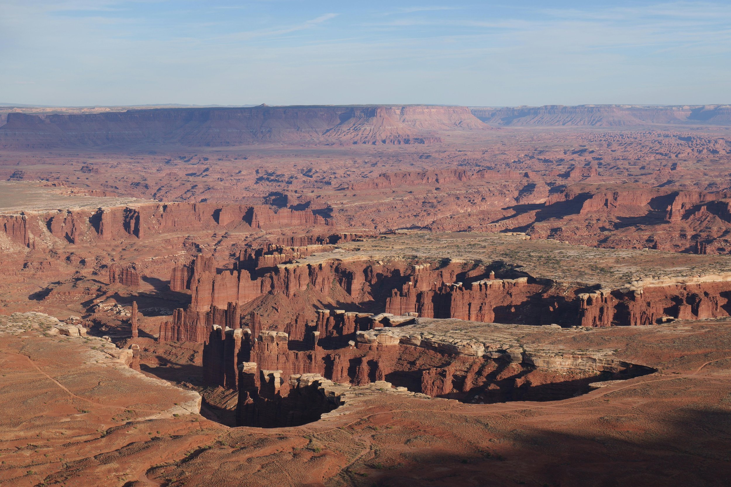 View of the Grand Canyon with layered rock formations and a clear sky.