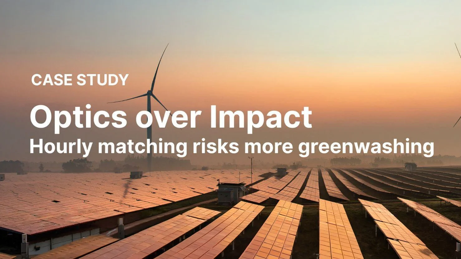 Solar panels on a large field with wind turbines in the background at sunset.