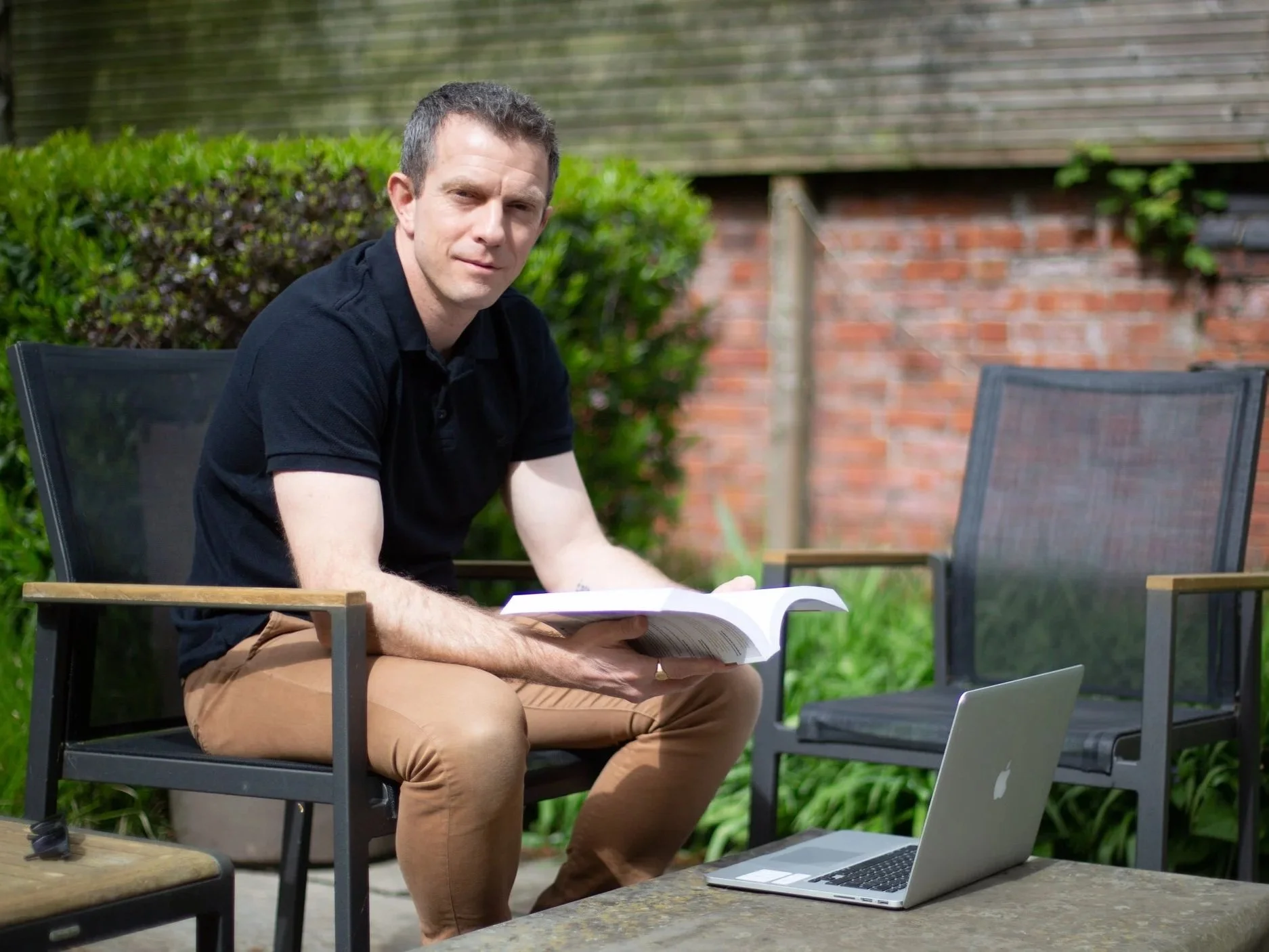 Dr Mike Marriott, Clinical Psychologist (Sat reading in a garden)