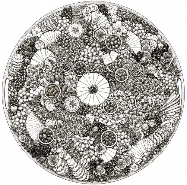 A large circular arrangement of various fruits, desserts, and snacks, including slices of cheese, citrus, berries, chocolates, and other decorative elements.