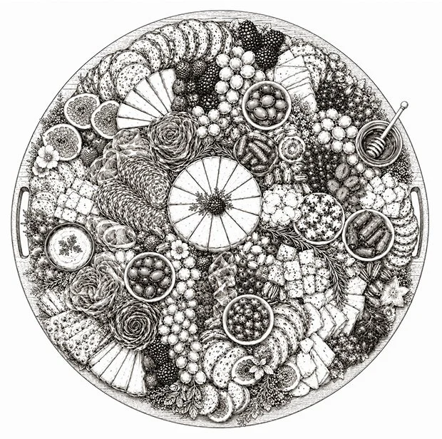 A large round serving tray filled with an assortment of fruits, desserts, and snacks, including slices of citrus, berries, cookies, chocolates, and decorative elements.