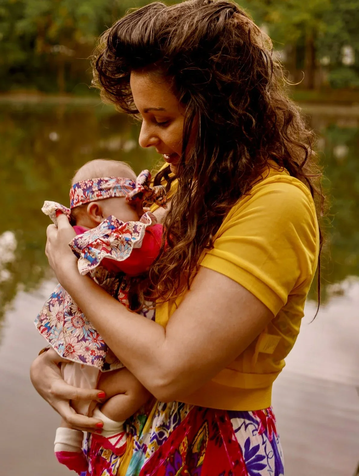Founder Alexis holding baby girl in a nature setting