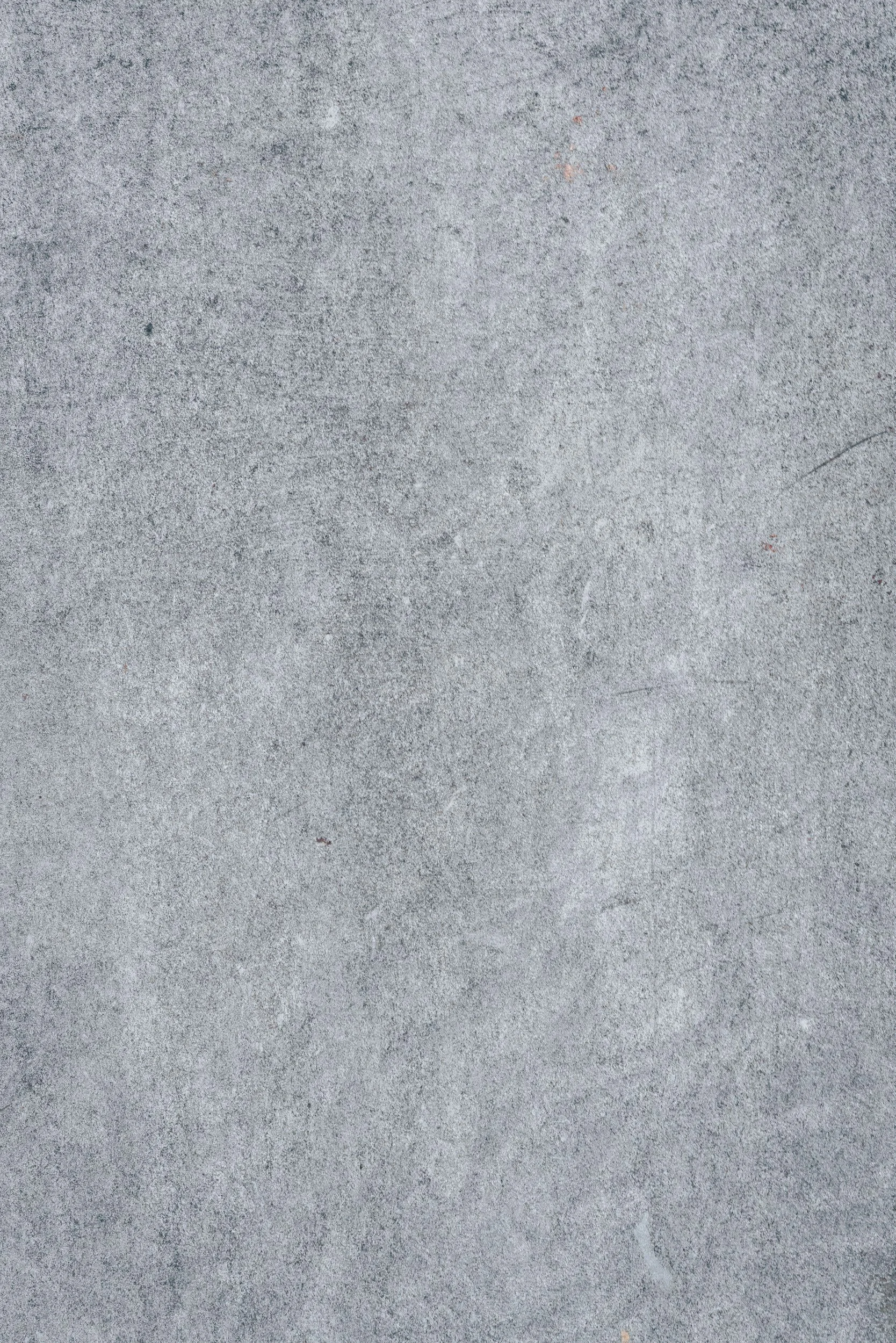 A smooth gray concrete surface with some small specks and scratches.