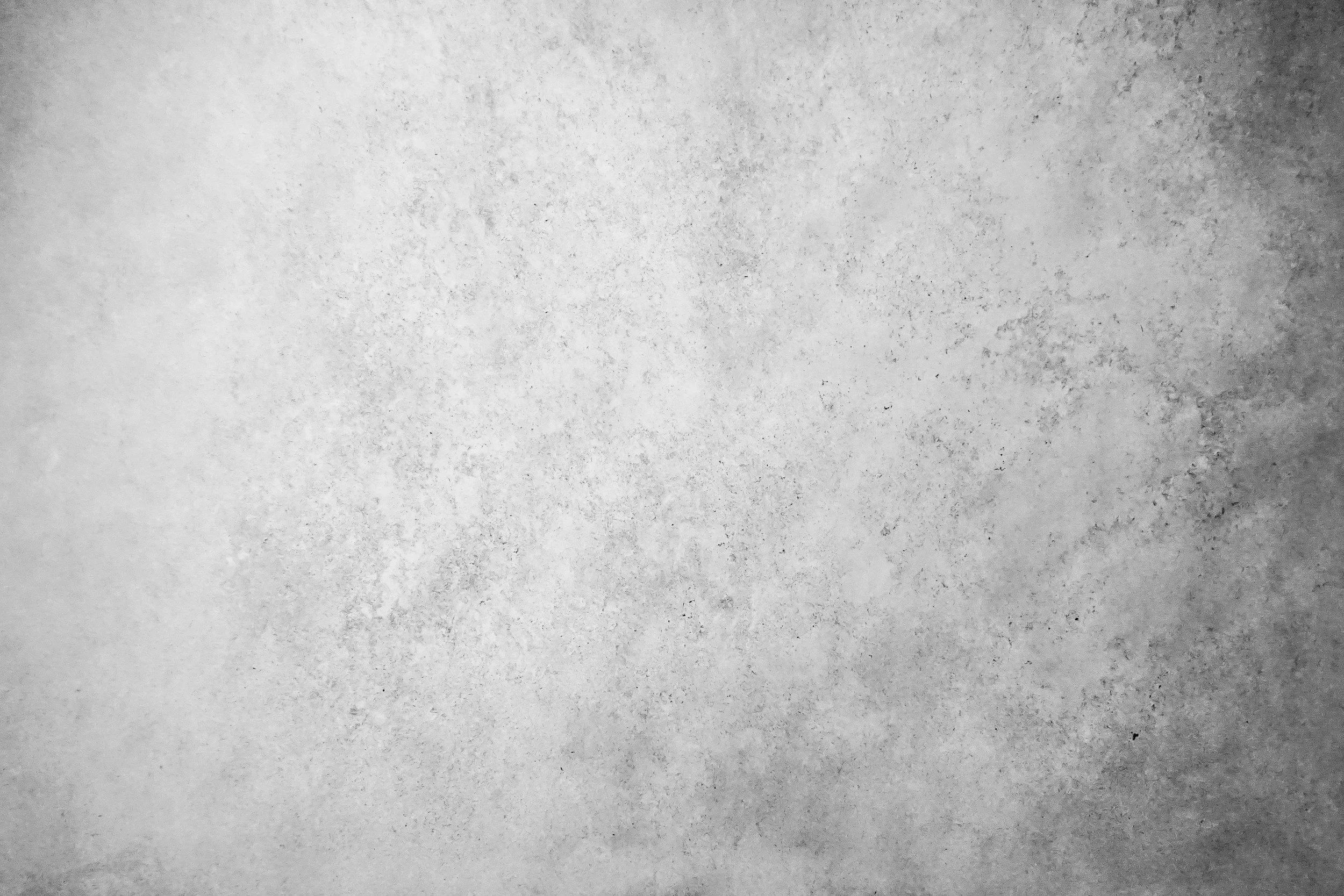 A textured, gradient gray wall with a rough surface.