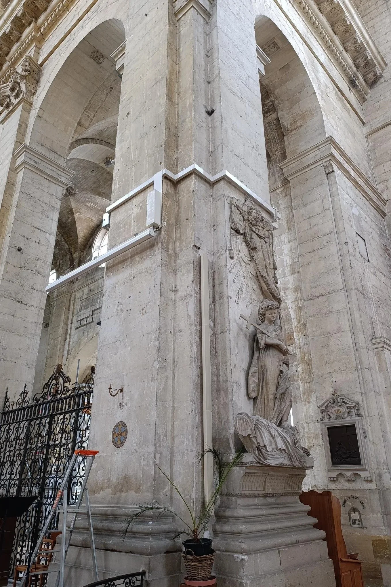 Vue intérieure d'une structure architecturale en pierre, avec une statue de femme tenant une épée, et des décorations sculptées.