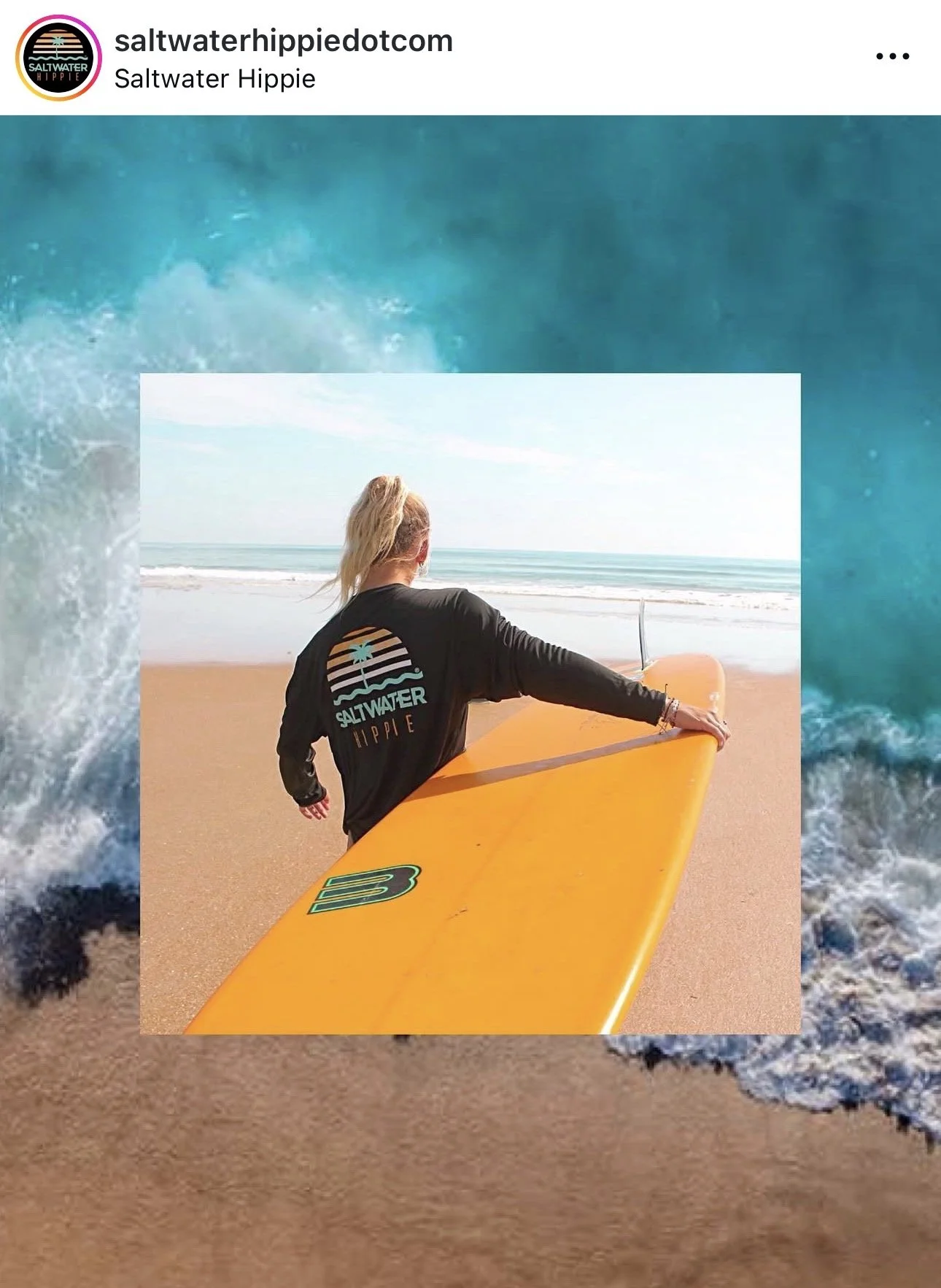 A woman on the beach holding a yellow surfboard while looking out at the ocean. She is wearing a black sweatshirt with a saltwater hippie logo on the back.
